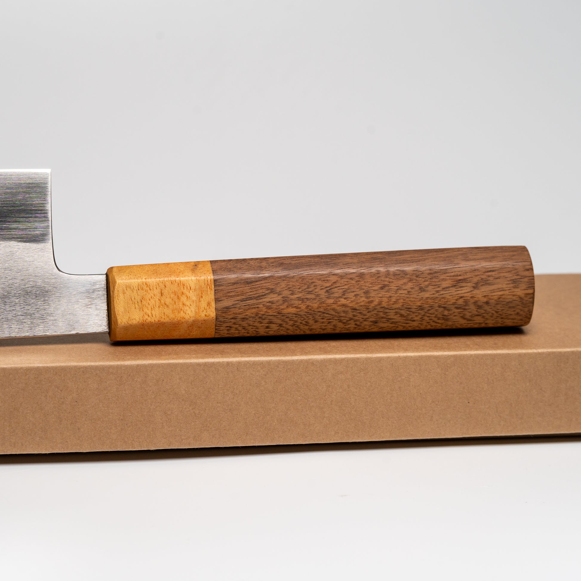 Close up of the handle of a Japanese Nakiri knife on its box