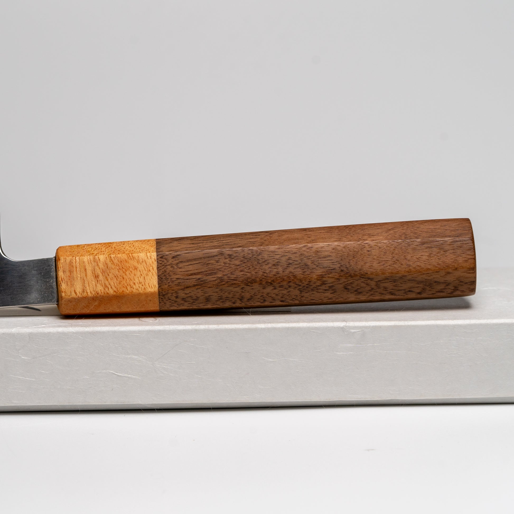 Close up of the handle of a Japanese paring knife on its box