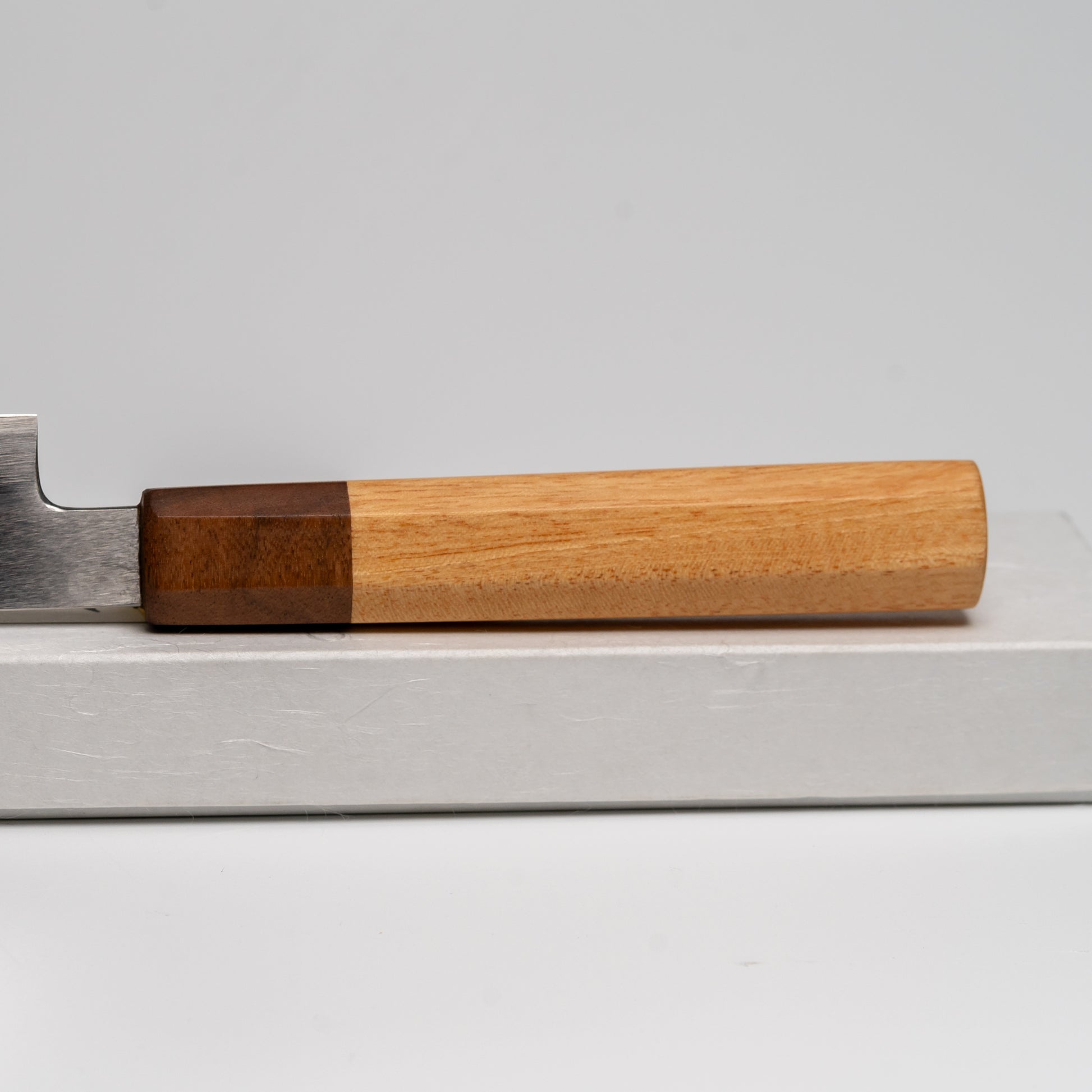 Close up of the handle of a Japanese paring knife on its box