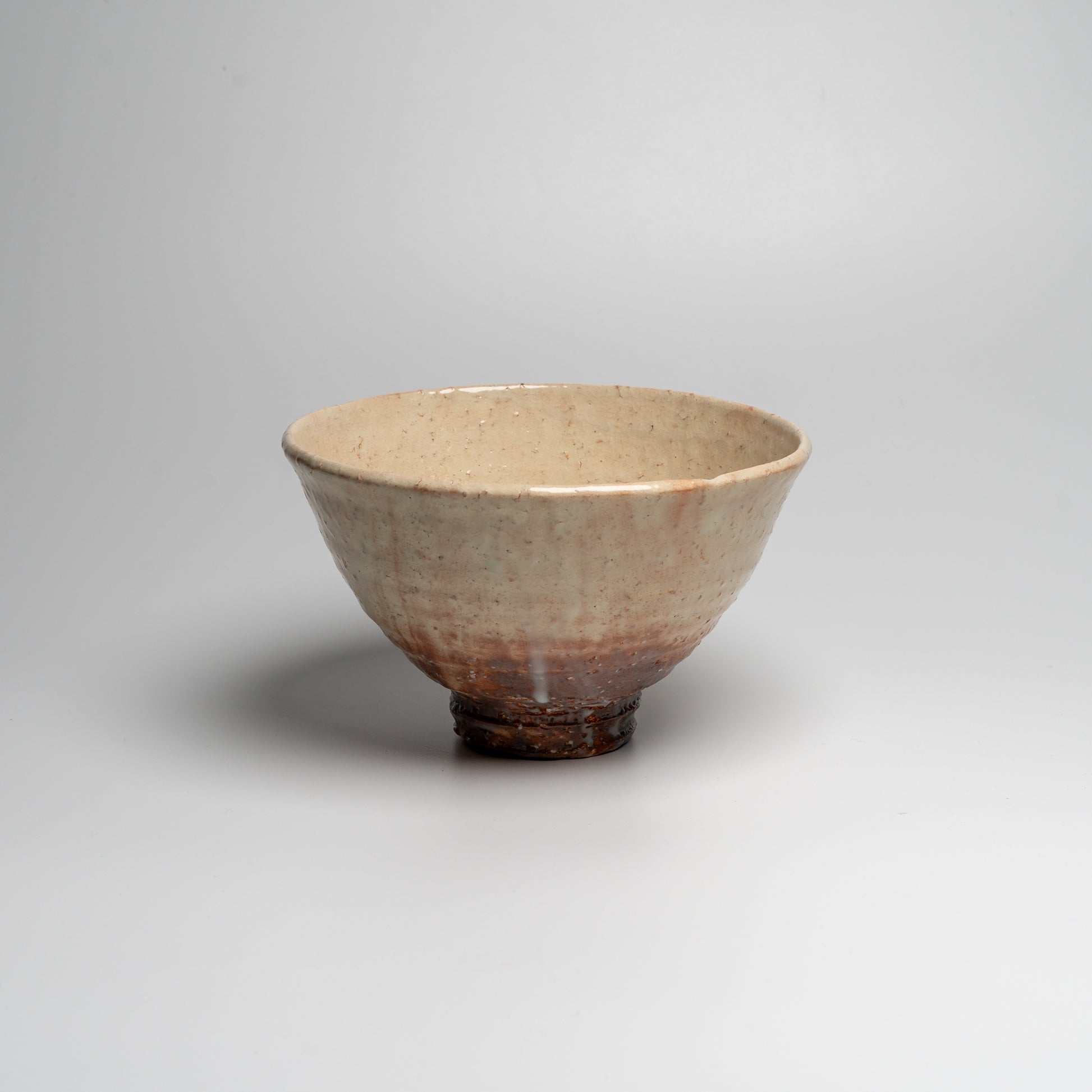 A Japanese ceramic ceremonial matcha tea bowl on a white background
