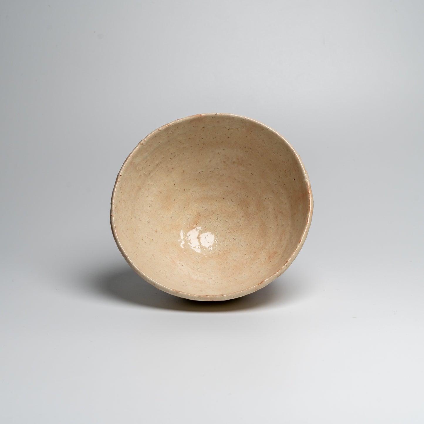 A Japanese ceramic ceremonial matcha tea bowl on a white background