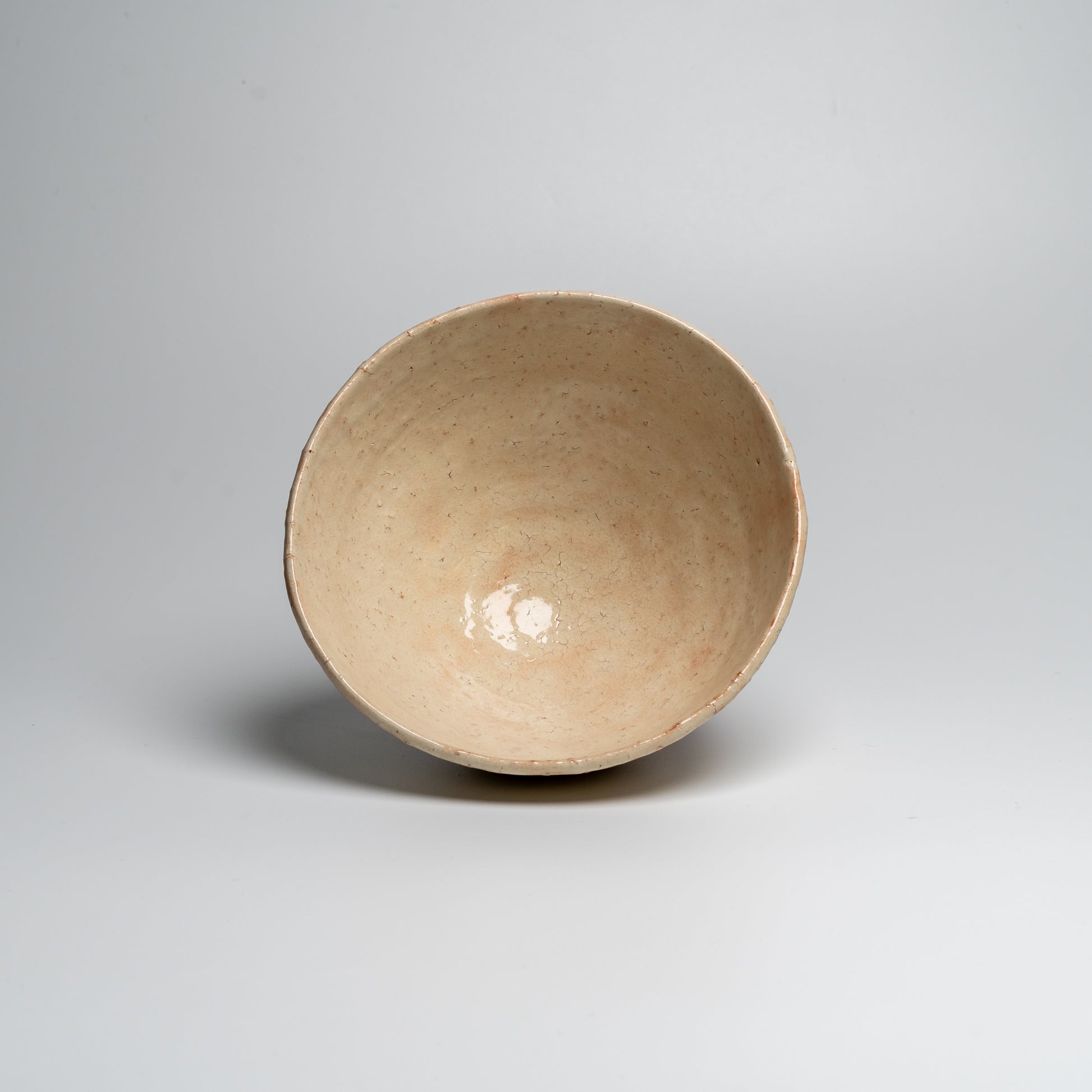A Japanese ceramic ceremonial matcha tea bowl on a white background