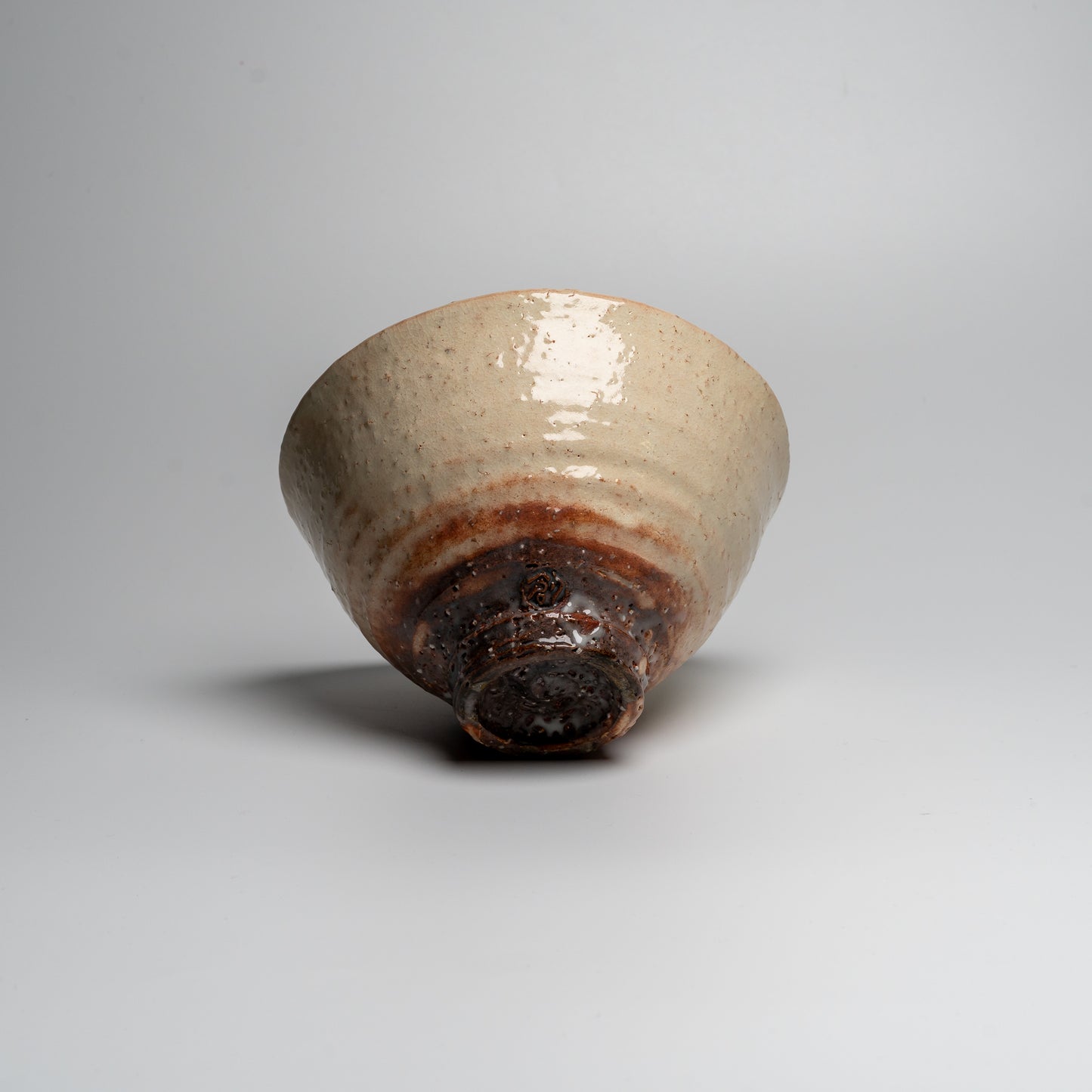A Japanese ceramic ceremonial matcha tea bowl on a white background