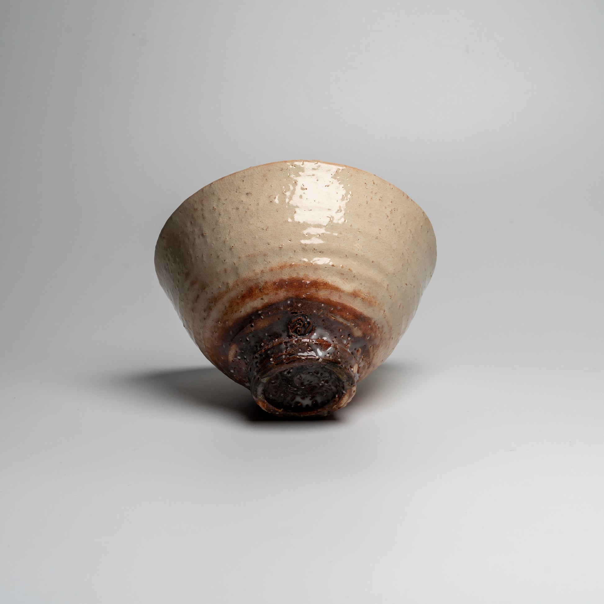 A Japanese ceramic ceremonial matcha tea bowl on a white background
