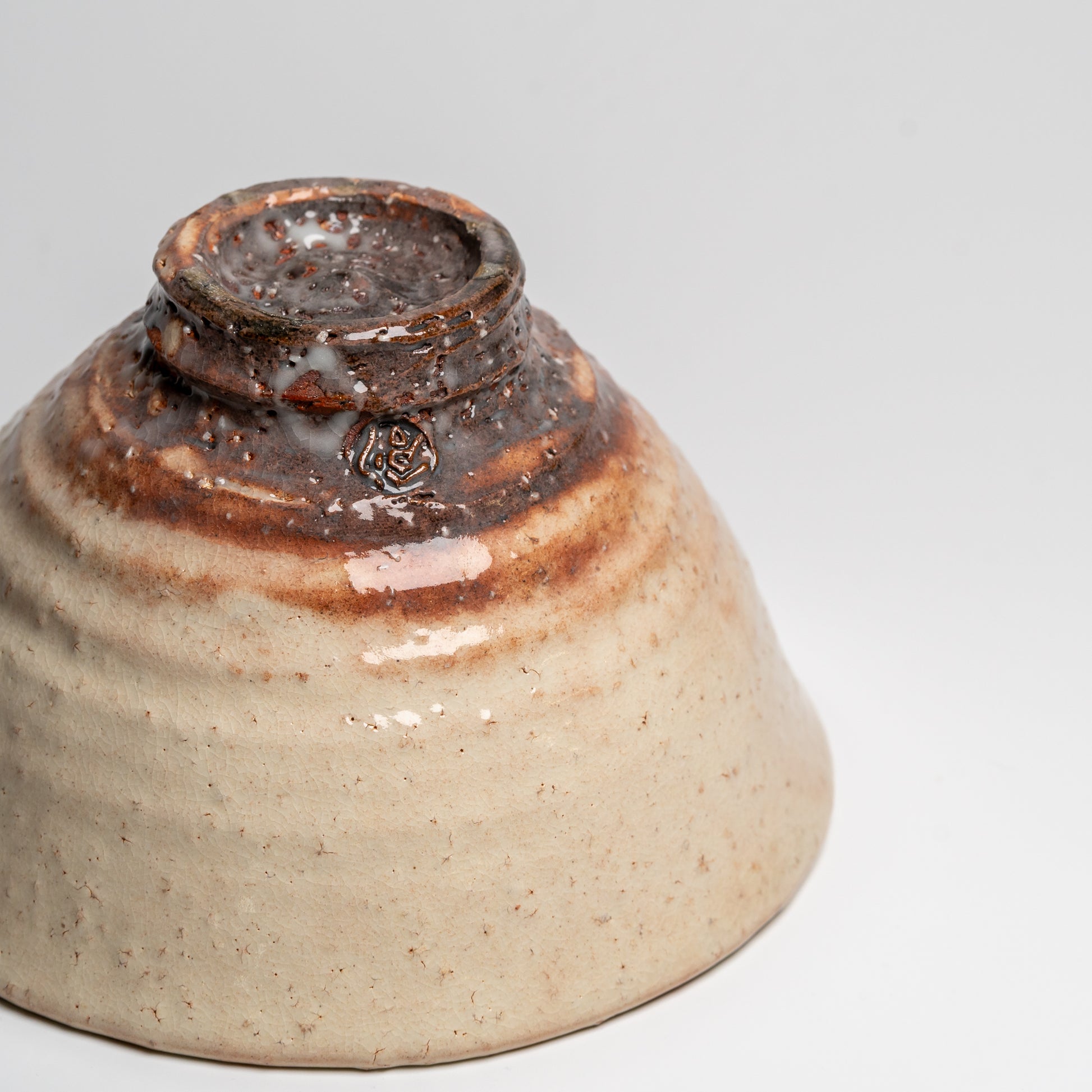 A Japanese ceramic ceremonial matcha tea bowl on a white background