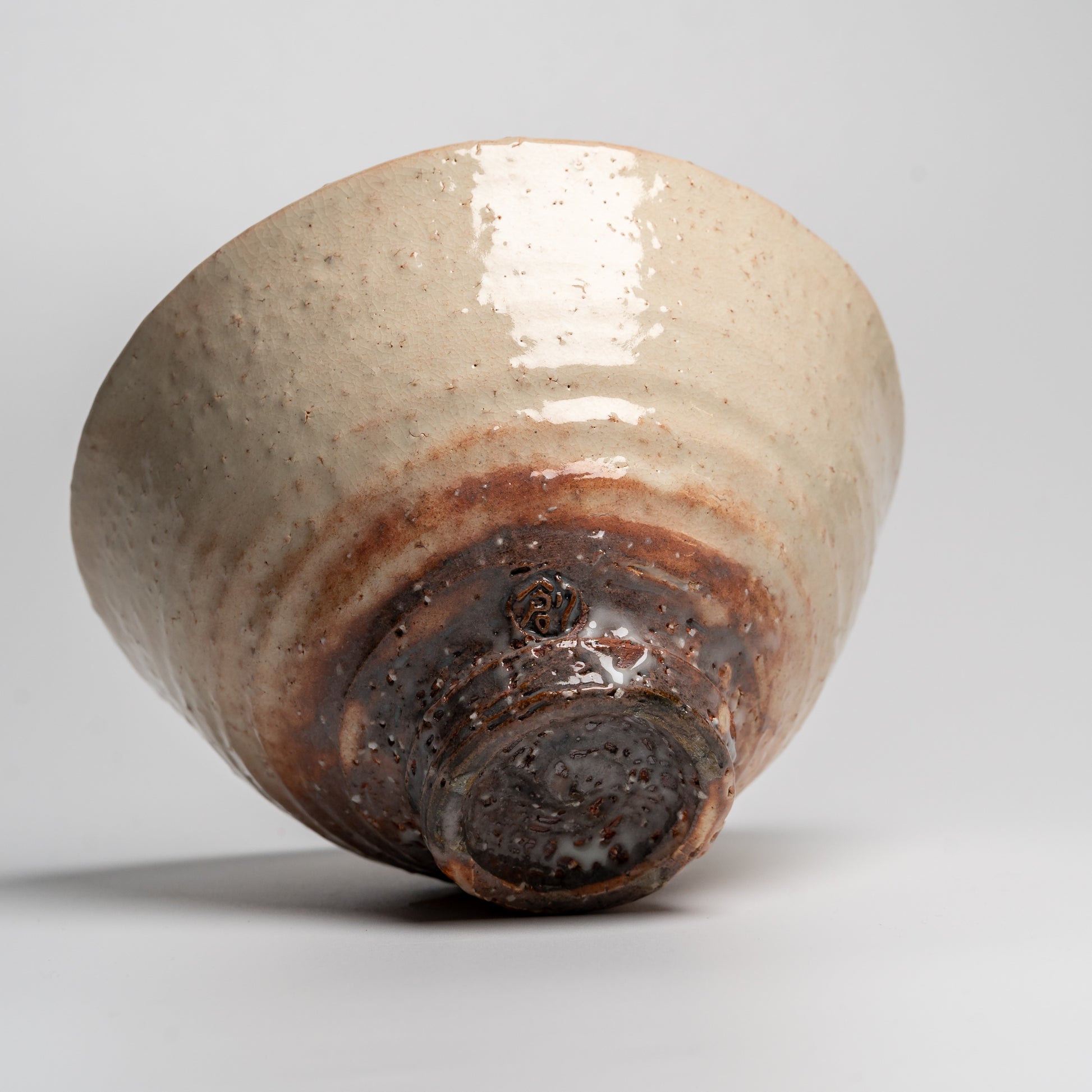 A Japanese ceramic ceremonial matcha tea bowl on a white background