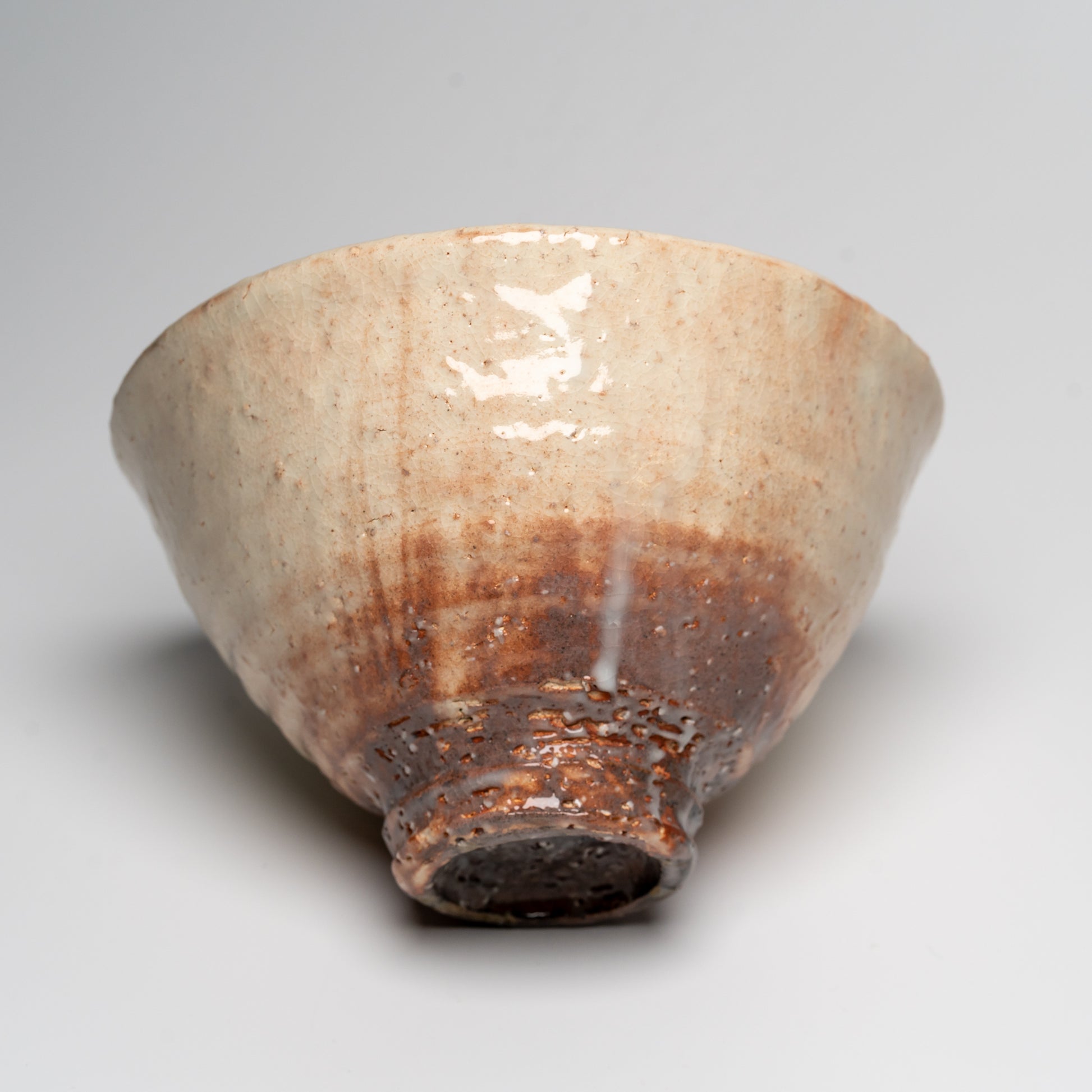 A Japanese ceramic ceremonial matcha tea bowl on a white background