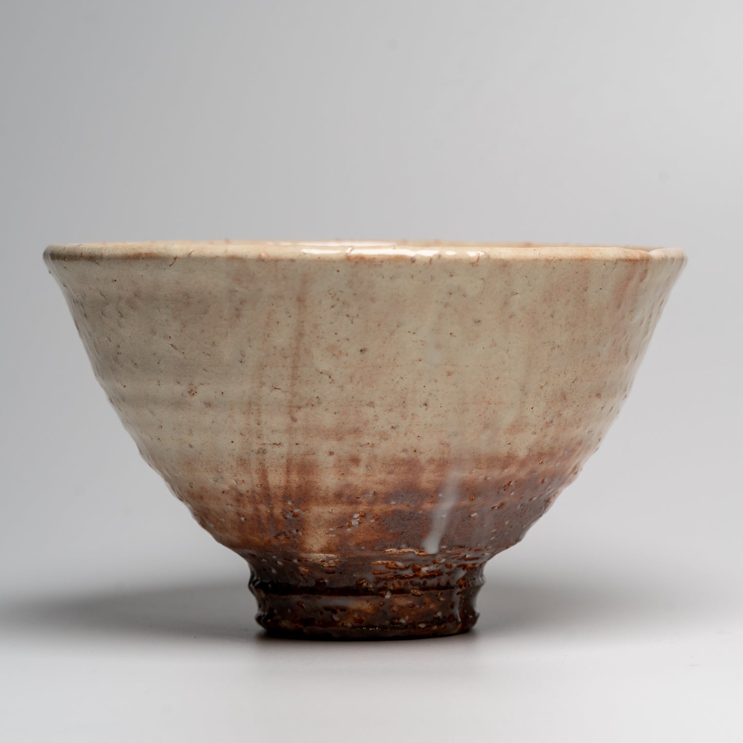 A Japanese ceramic ceremonial matcha tea bowl on a white background
