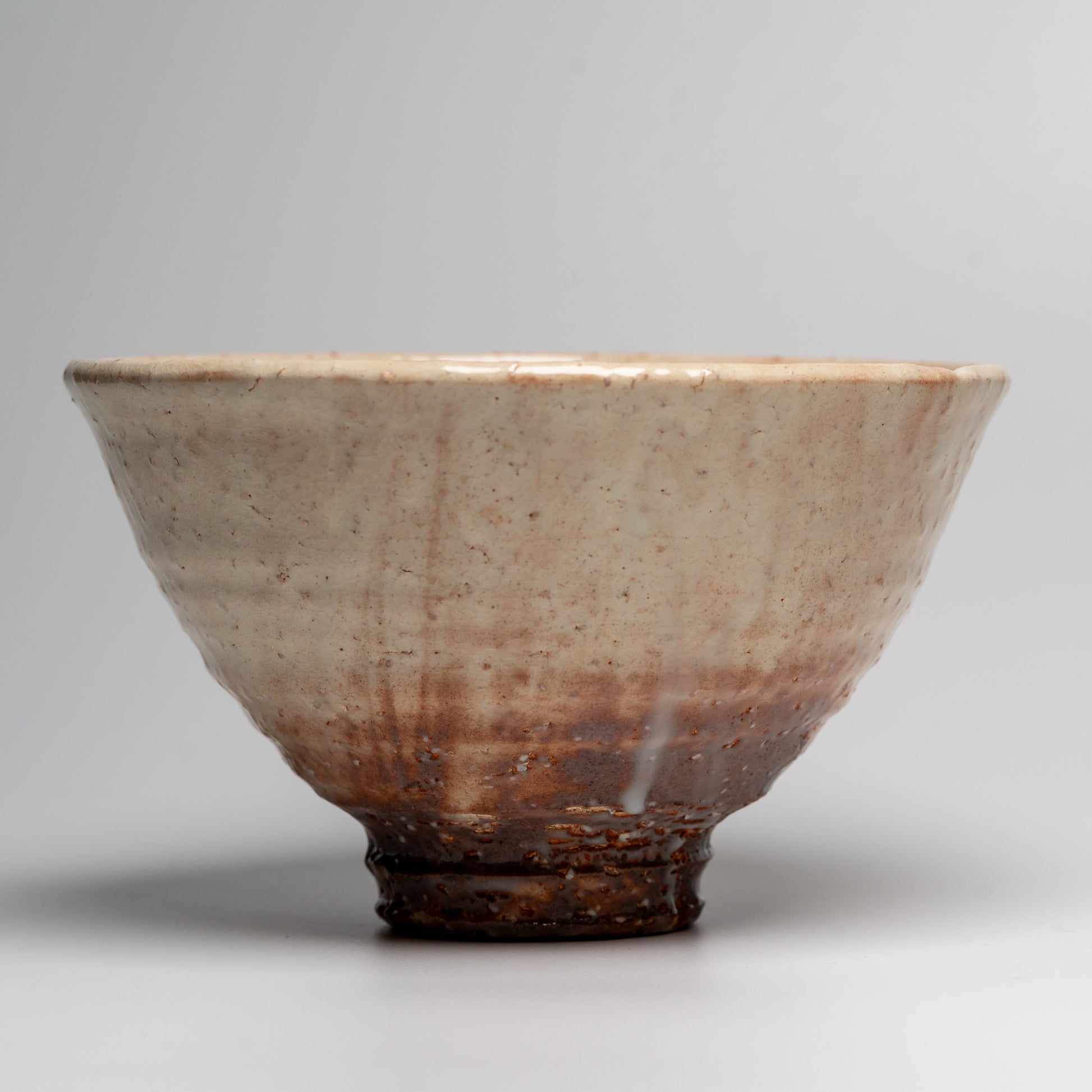 A Japanese ceramic ceremonial matcha tea bowl on a white background