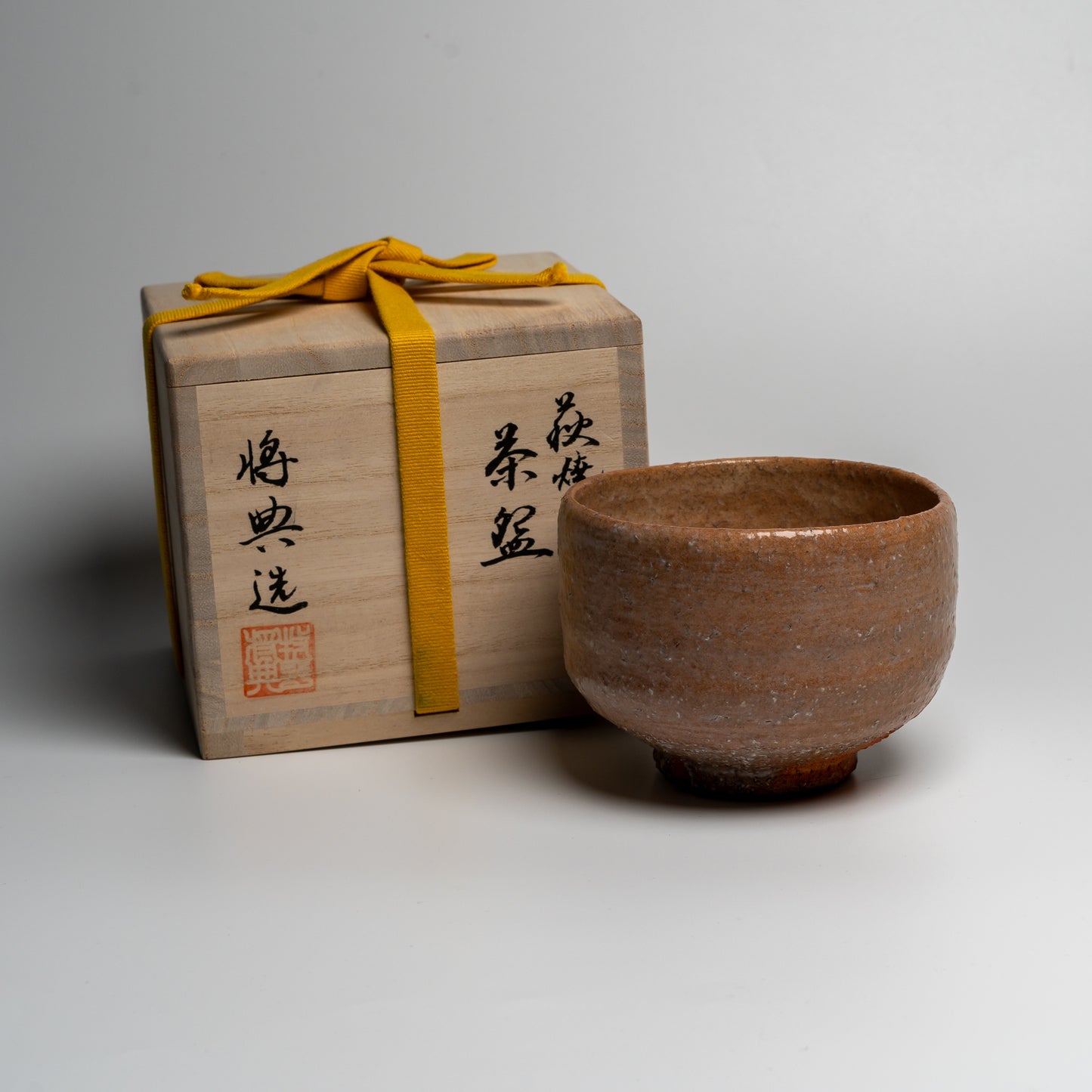 Japanese ceramic matcha tea bowl with its box on white