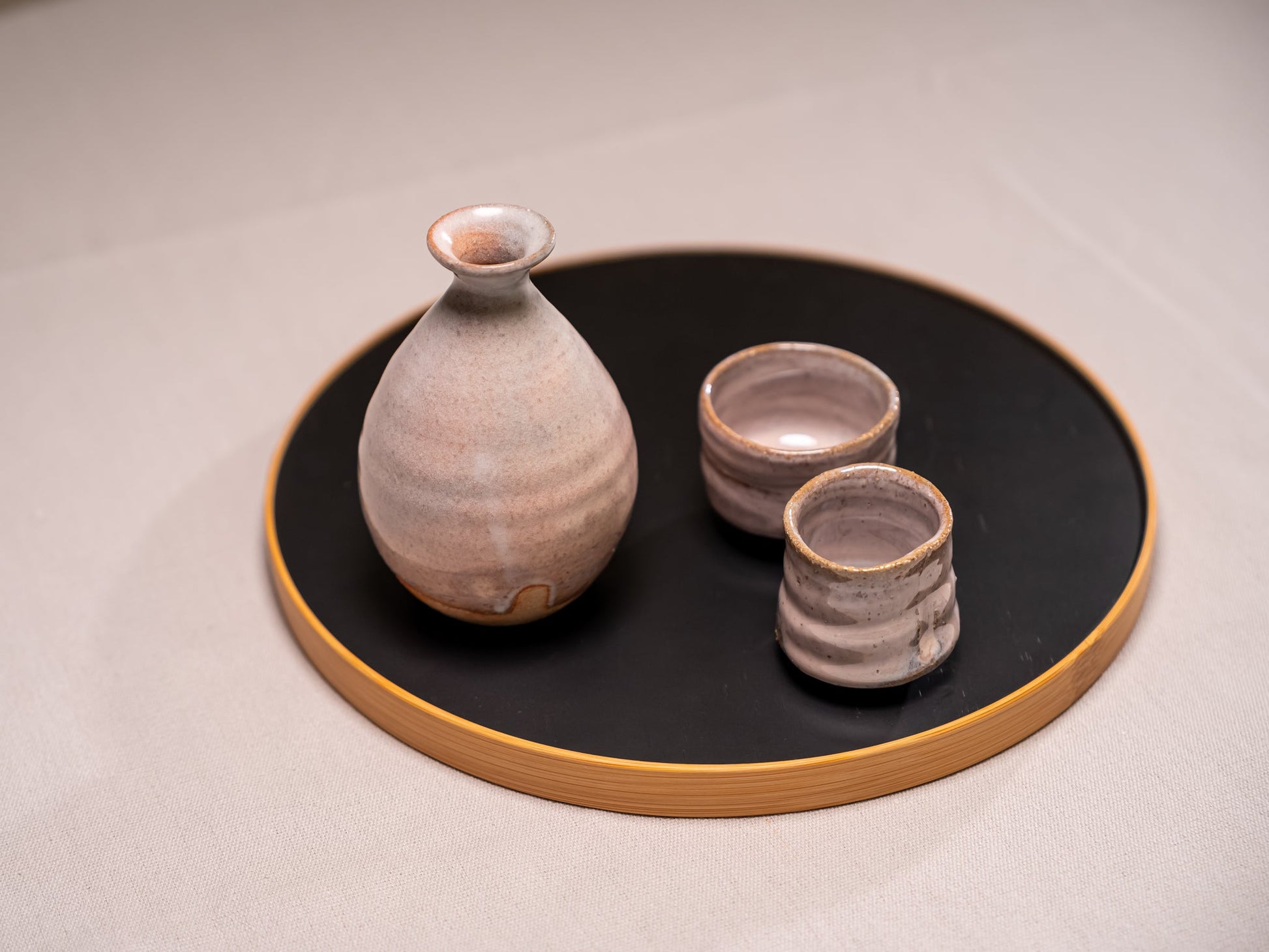 A Japanese ceramic sake set on a bamboo tray
