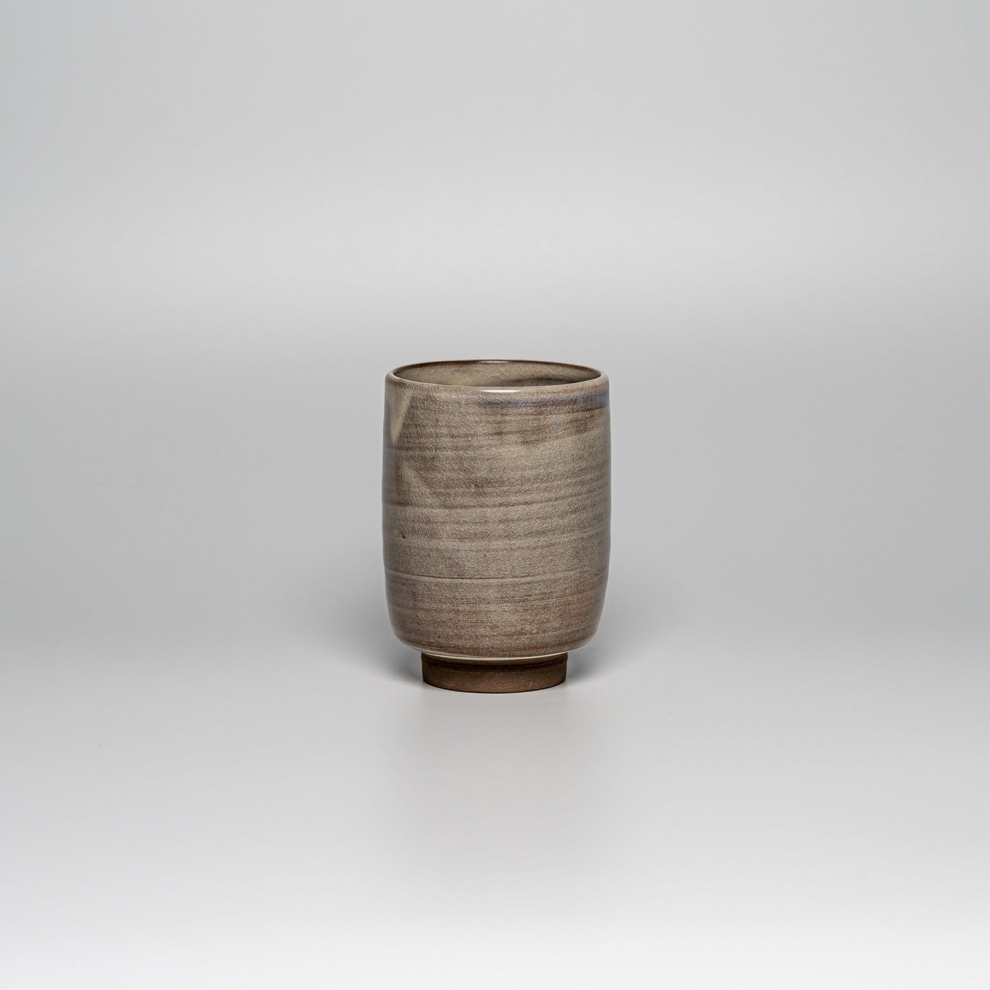 A brown Hagi yaki teacup on a white background