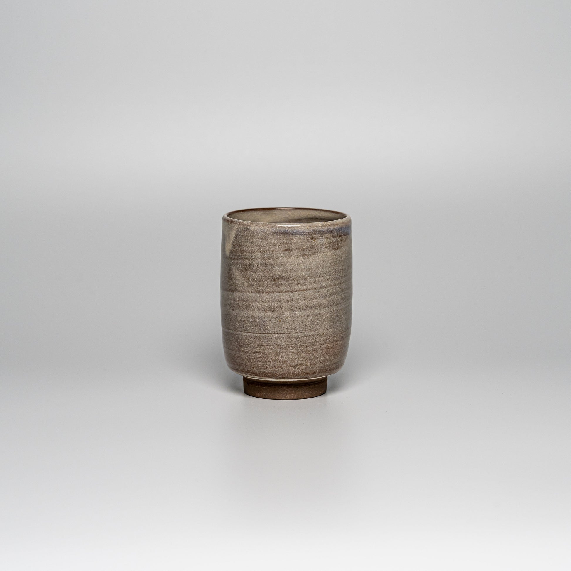 A brown Hagi yaki teacup on a white background