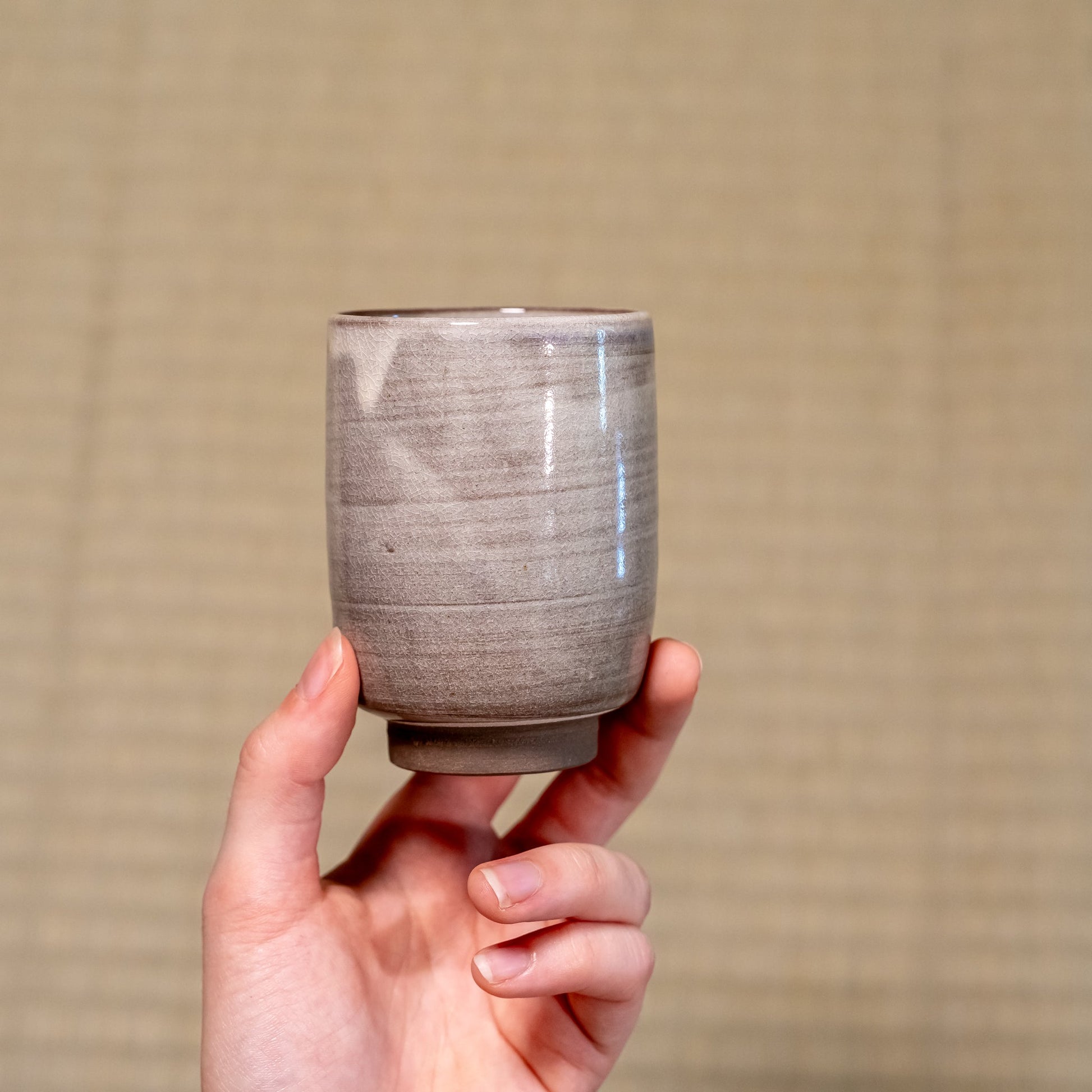 A Japanese ceramic Hagi yaki cup held in hand