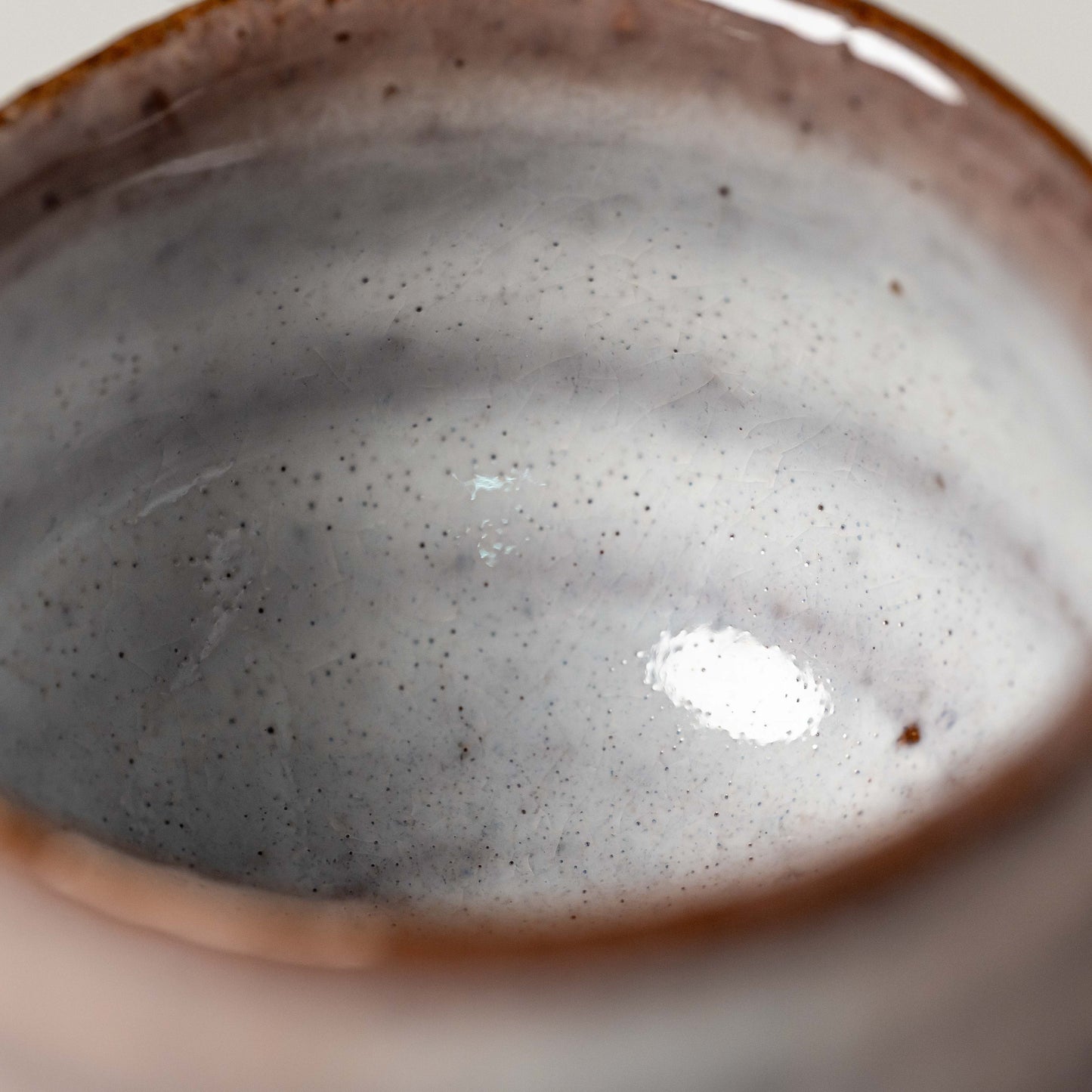 A close up of the inside of a pink and white Hagi yaki sake cup