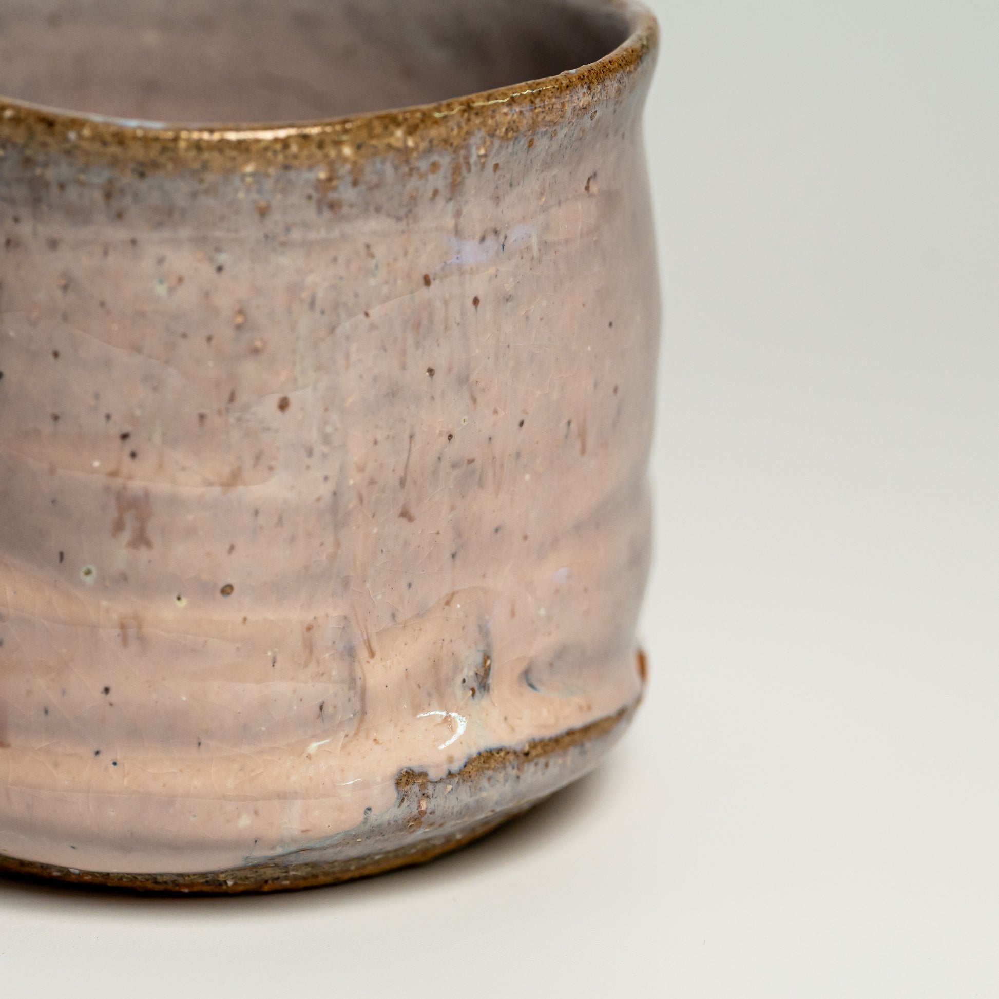 A close up of a pink Hagi yaki shochu cup on a white background