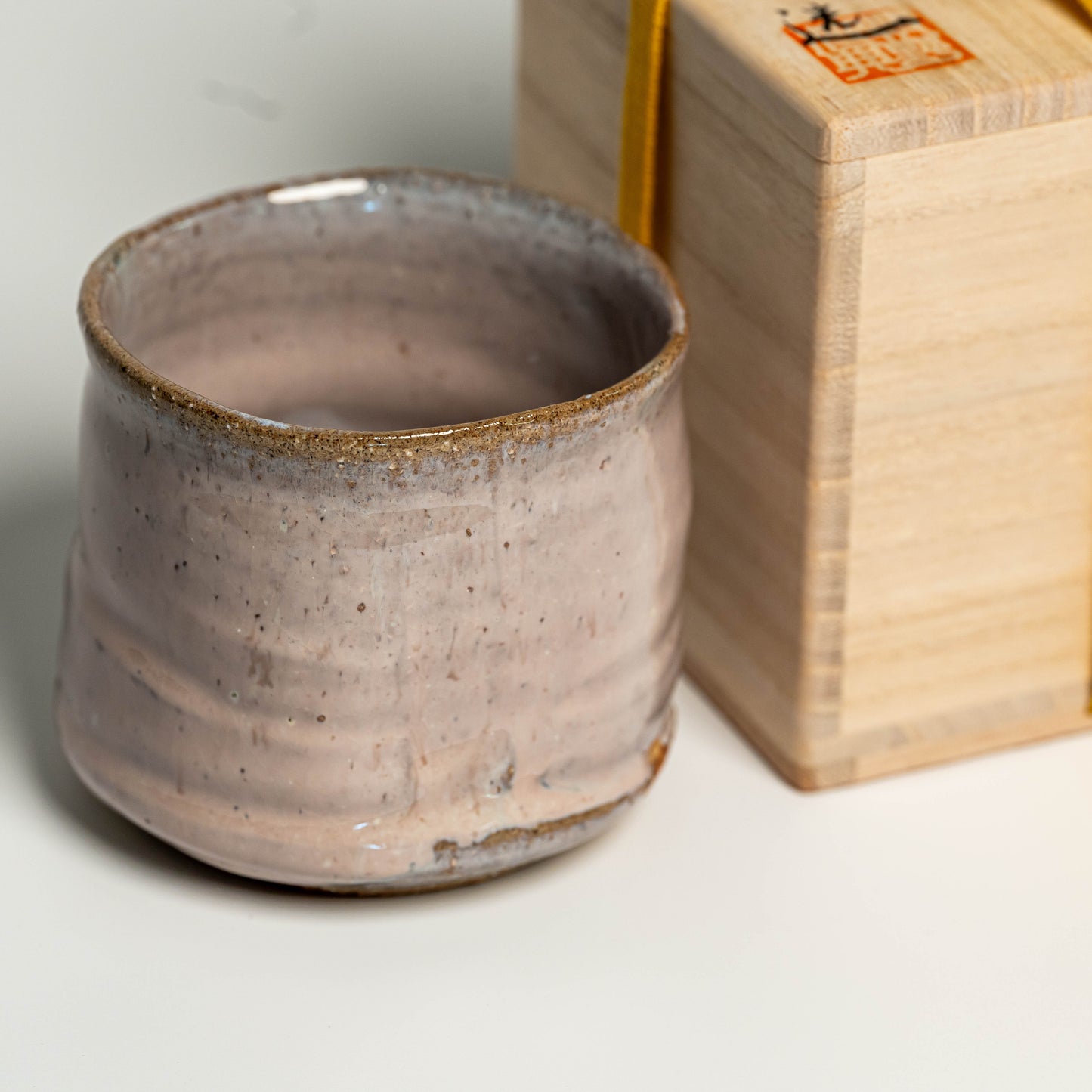A close up of a pink Hagi yaki shochu cup on a white background