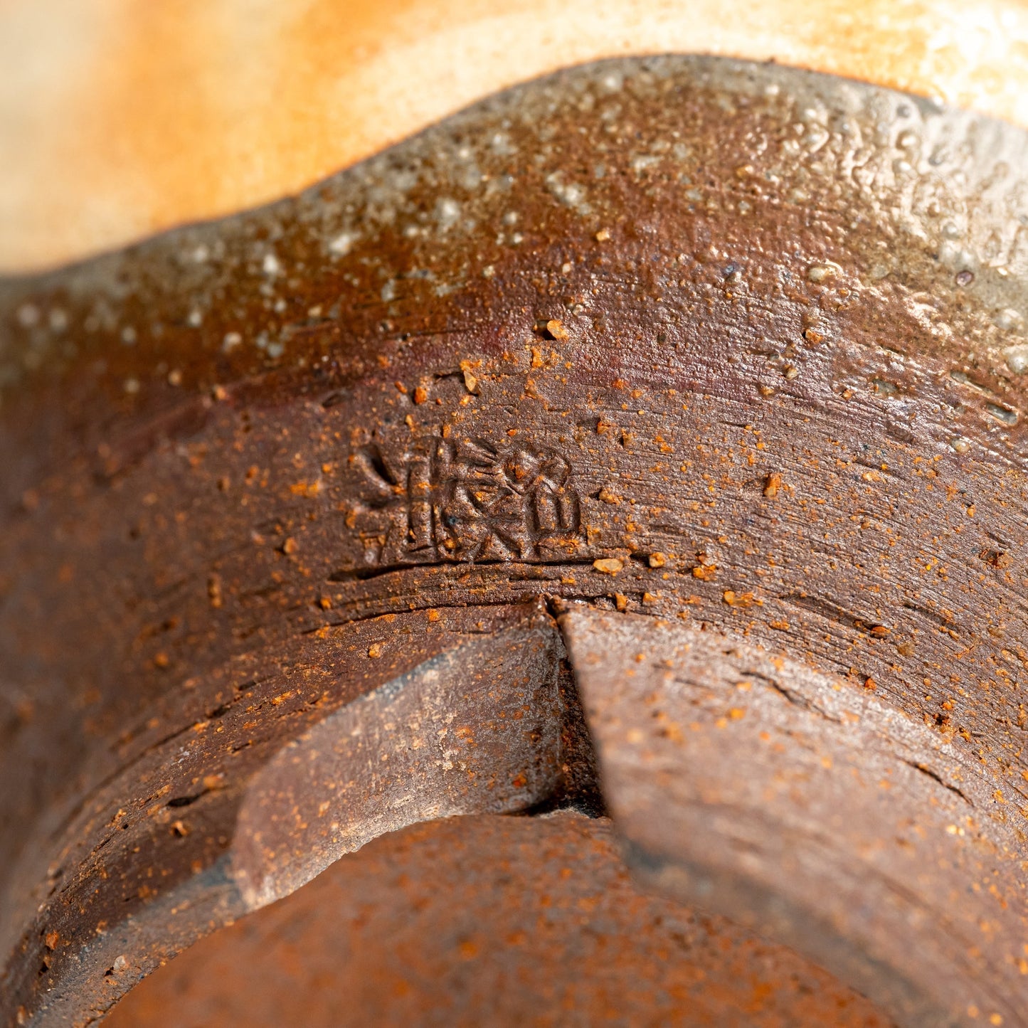 A close up of the bottom of a small Hagi yaki bowl on a white background