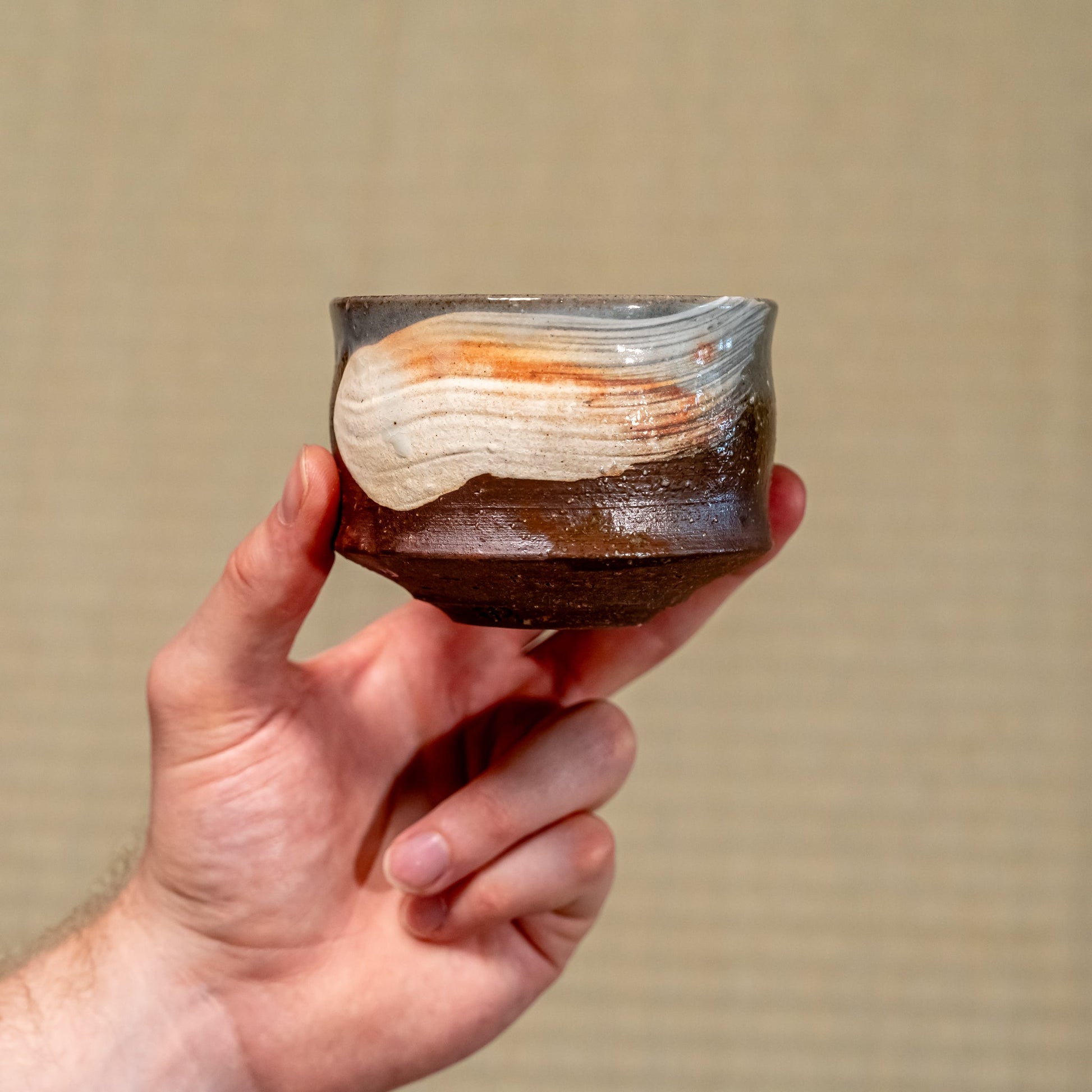 A Japanese ceramic Hagi yaki cup held in hand
