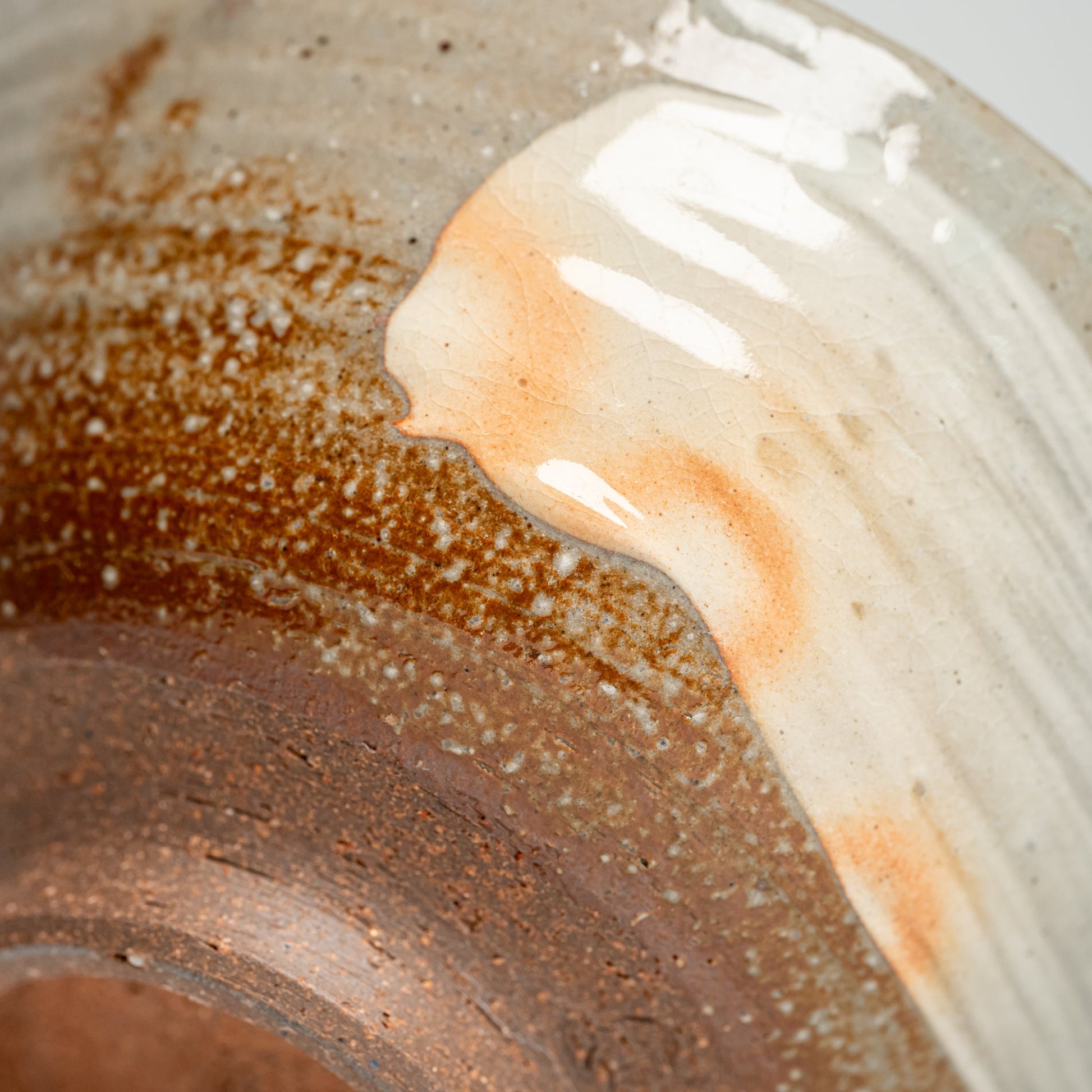 A close up of the bottom of a Japanese Hagi yaki rice bowl on a white background