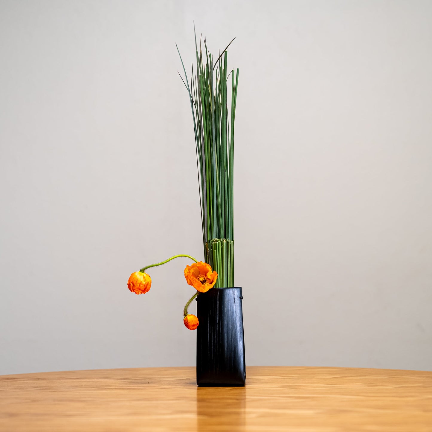 A Japanese bamboo vase with an ikebana inspired flower arrangement