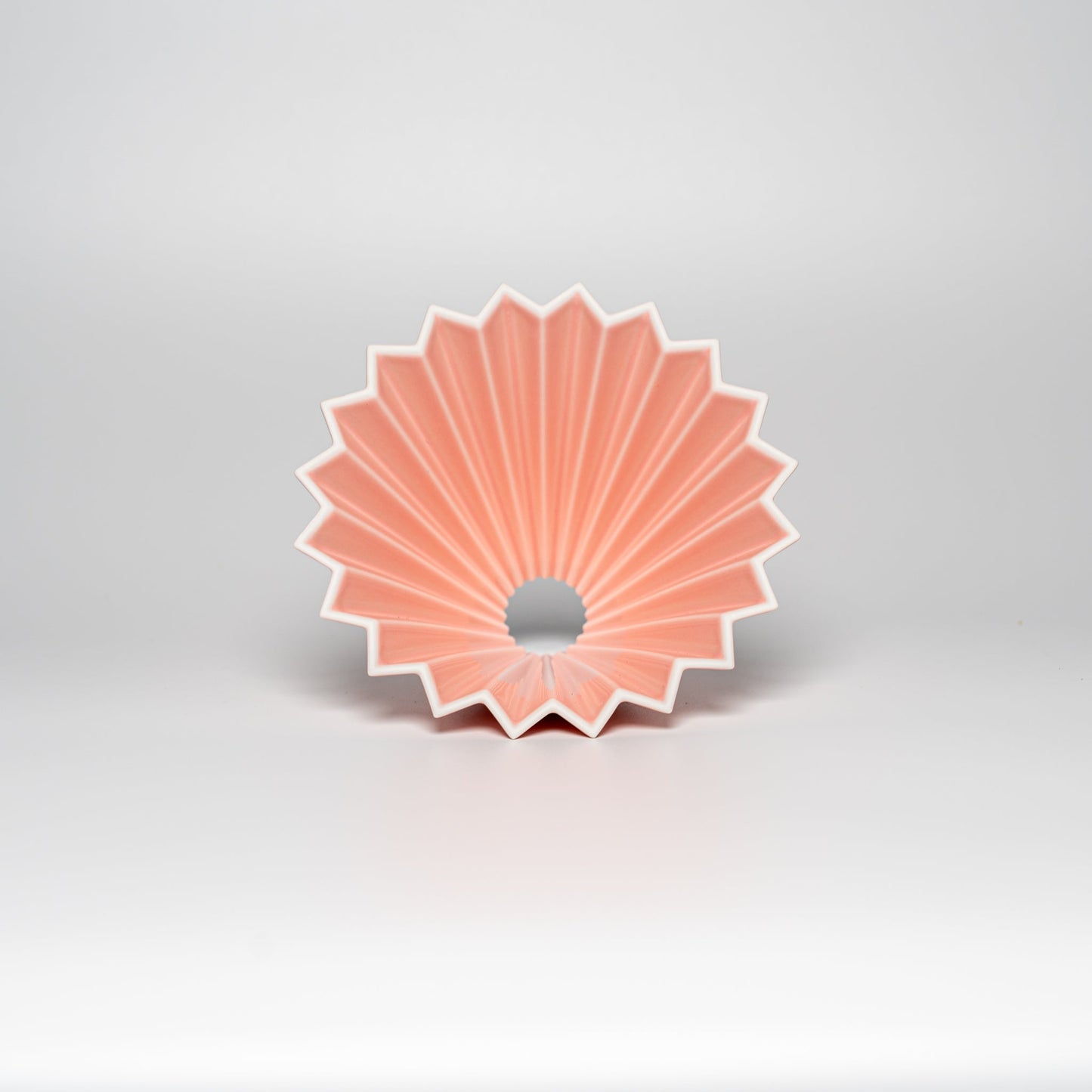 A matte pink ORIGAMI coffee dripper on a white background