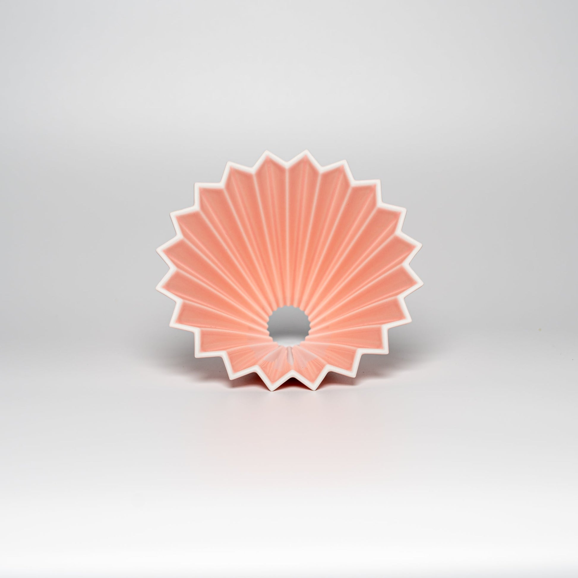 A matte pink ORIGAMI coffee dripper on a white background