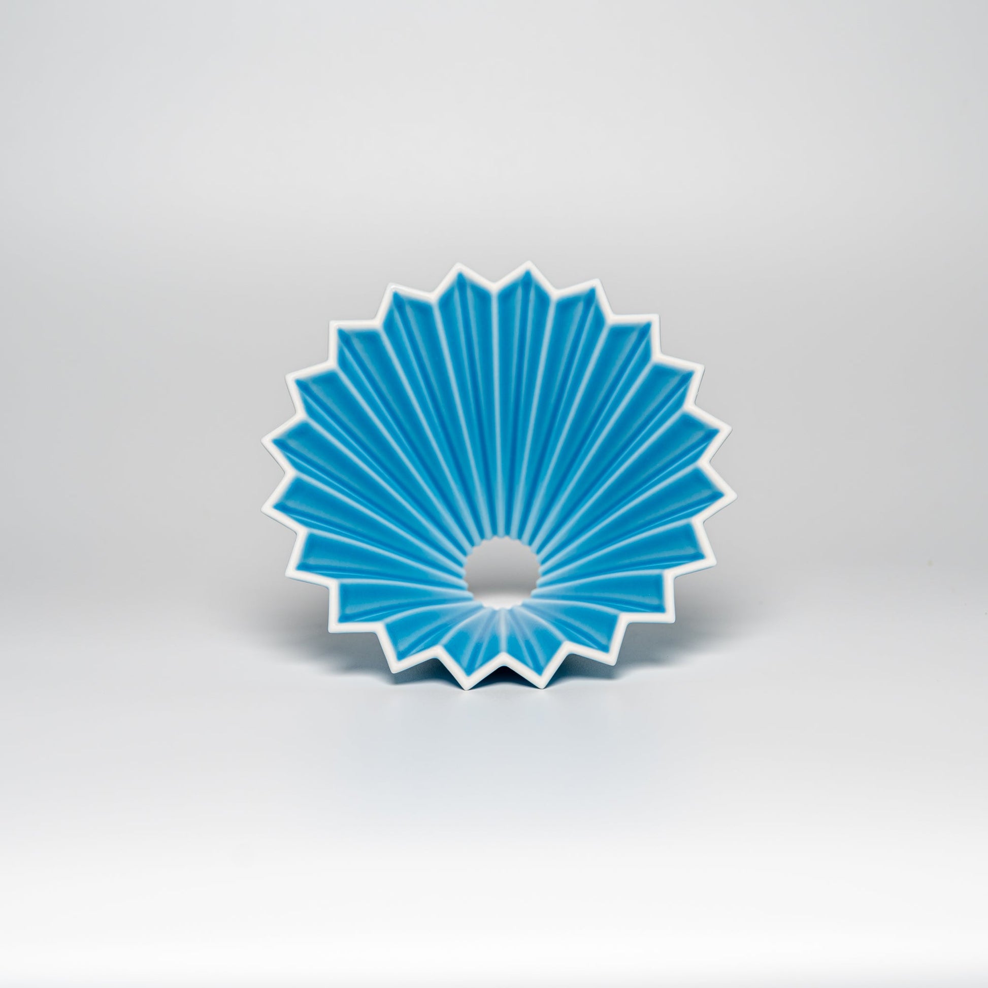 A bright blue ORIGAMI coffee dripper on a white background