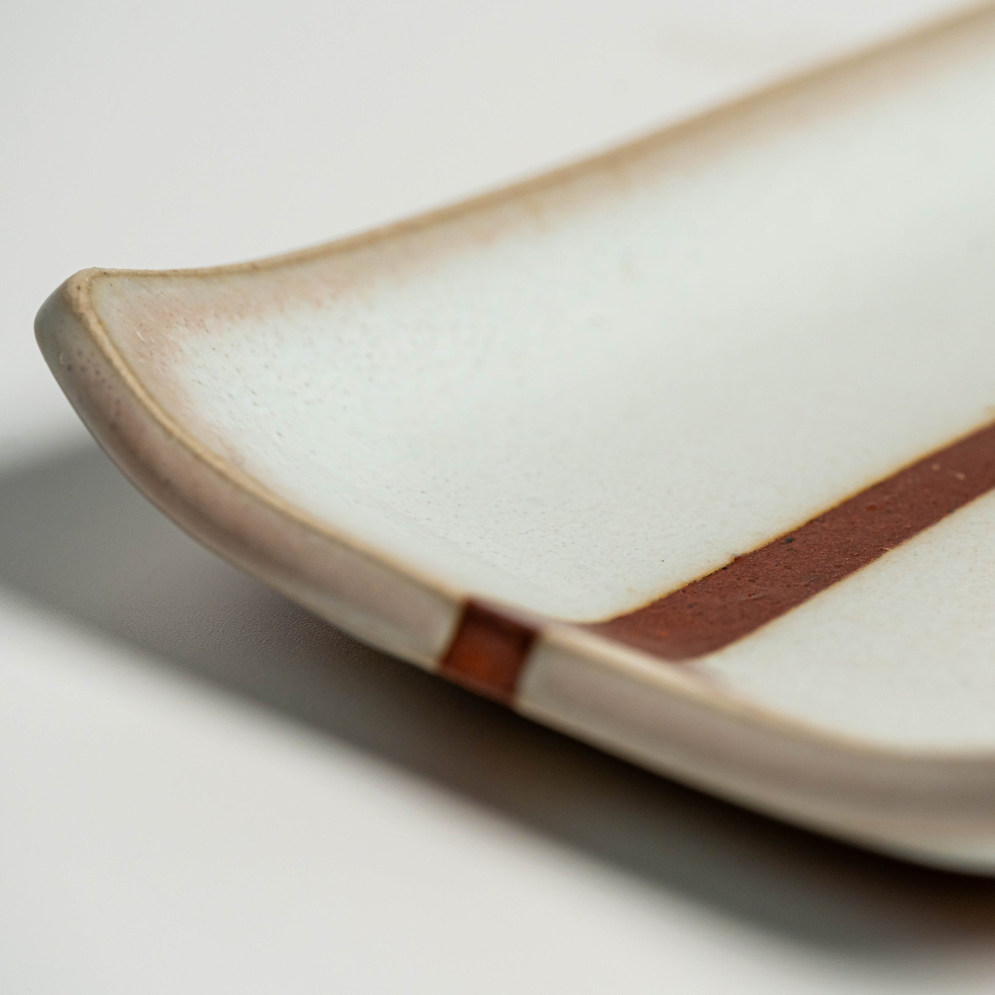 A close up of a white Hagi yaki plate on a white background