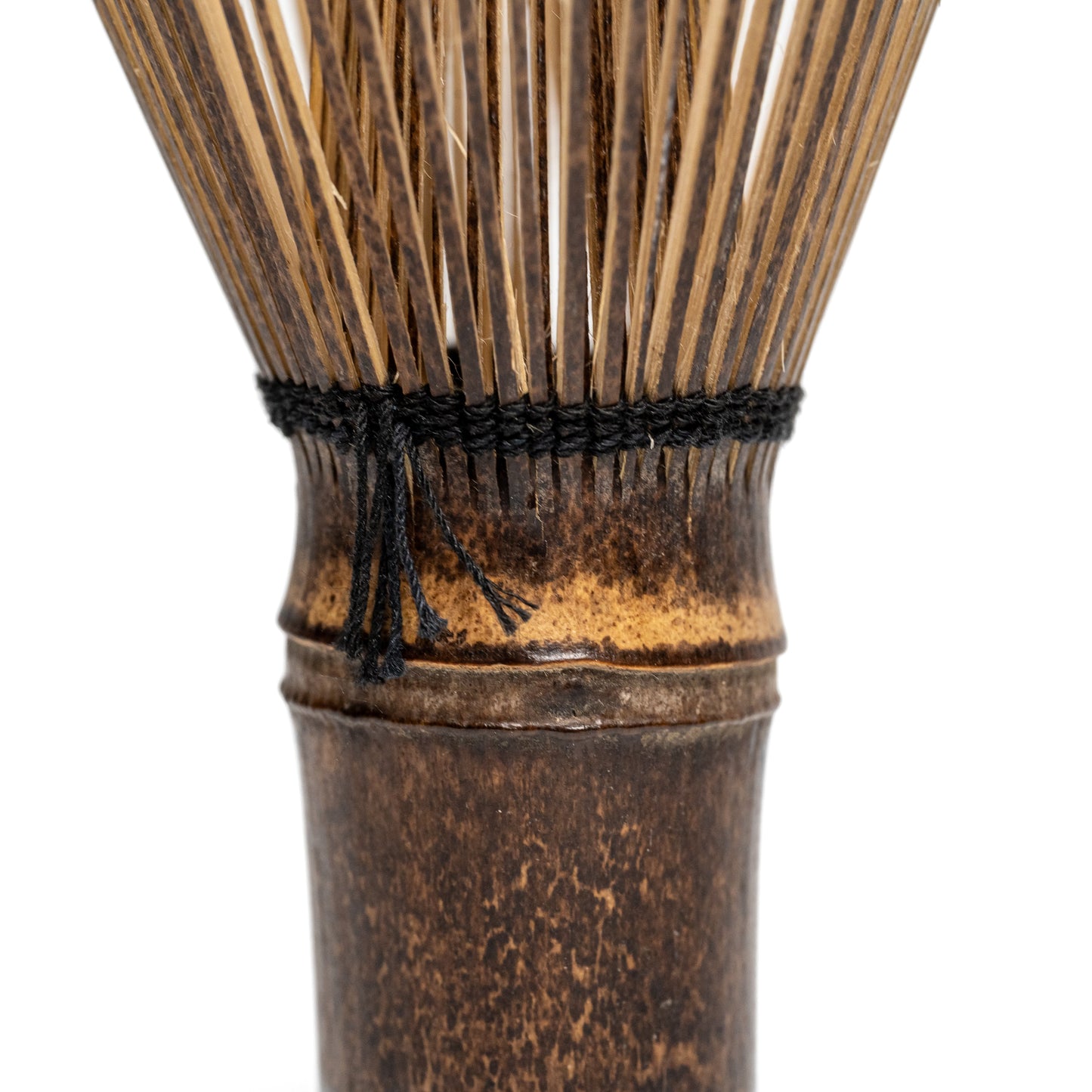 Close up of a black bamboo Takayama Chasen matcha whisk on a white background