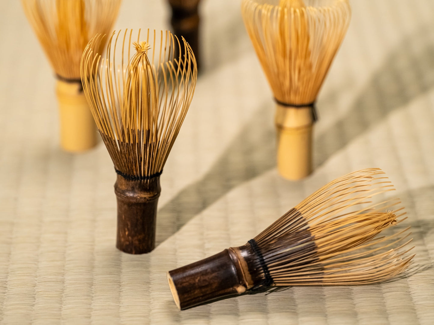 Japanese matcha whisks on a tatami mat