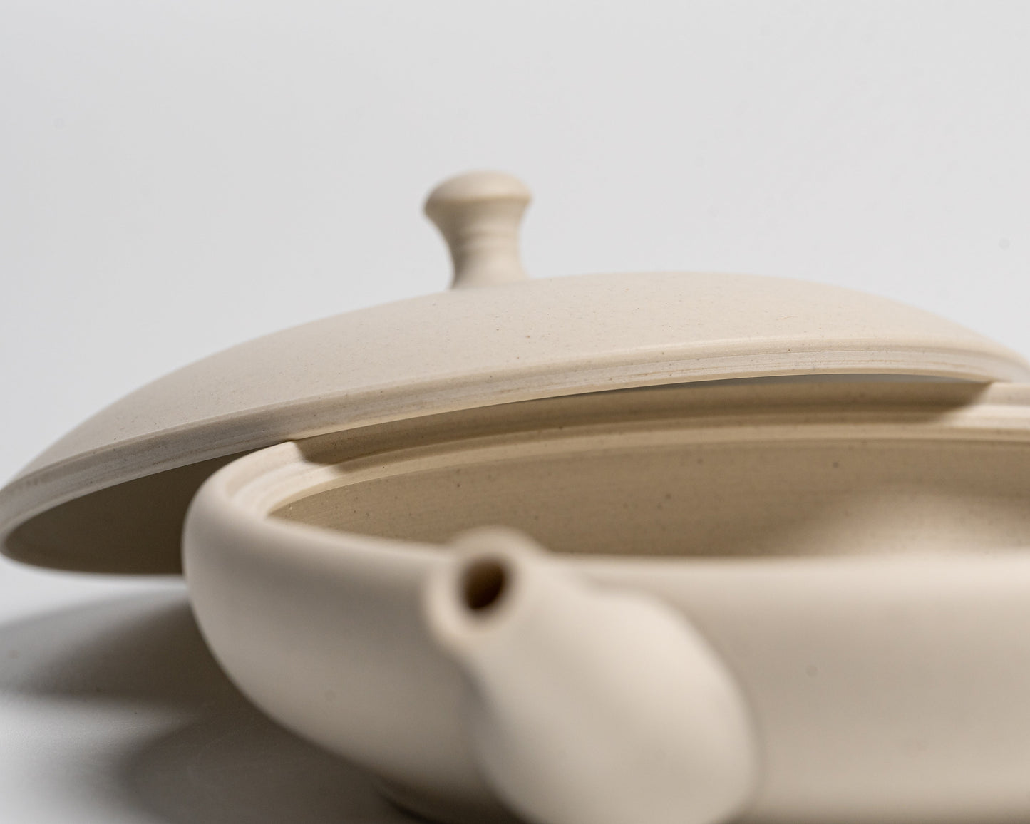 A close up of the Tokoname-yaki Teapot with the lid off on a white background