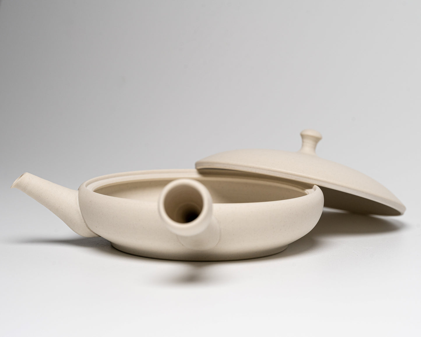 A Tokoname-yaki Teapot with the lid off on a white background