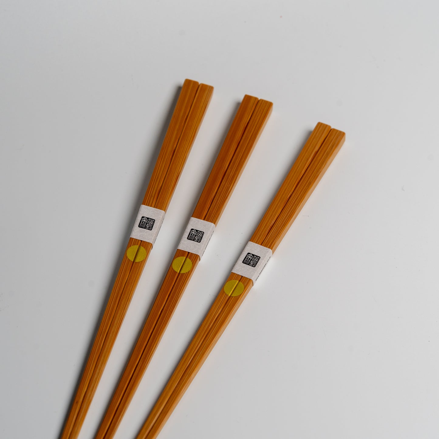 Japanese bamboo chopsticks with gold circles on white