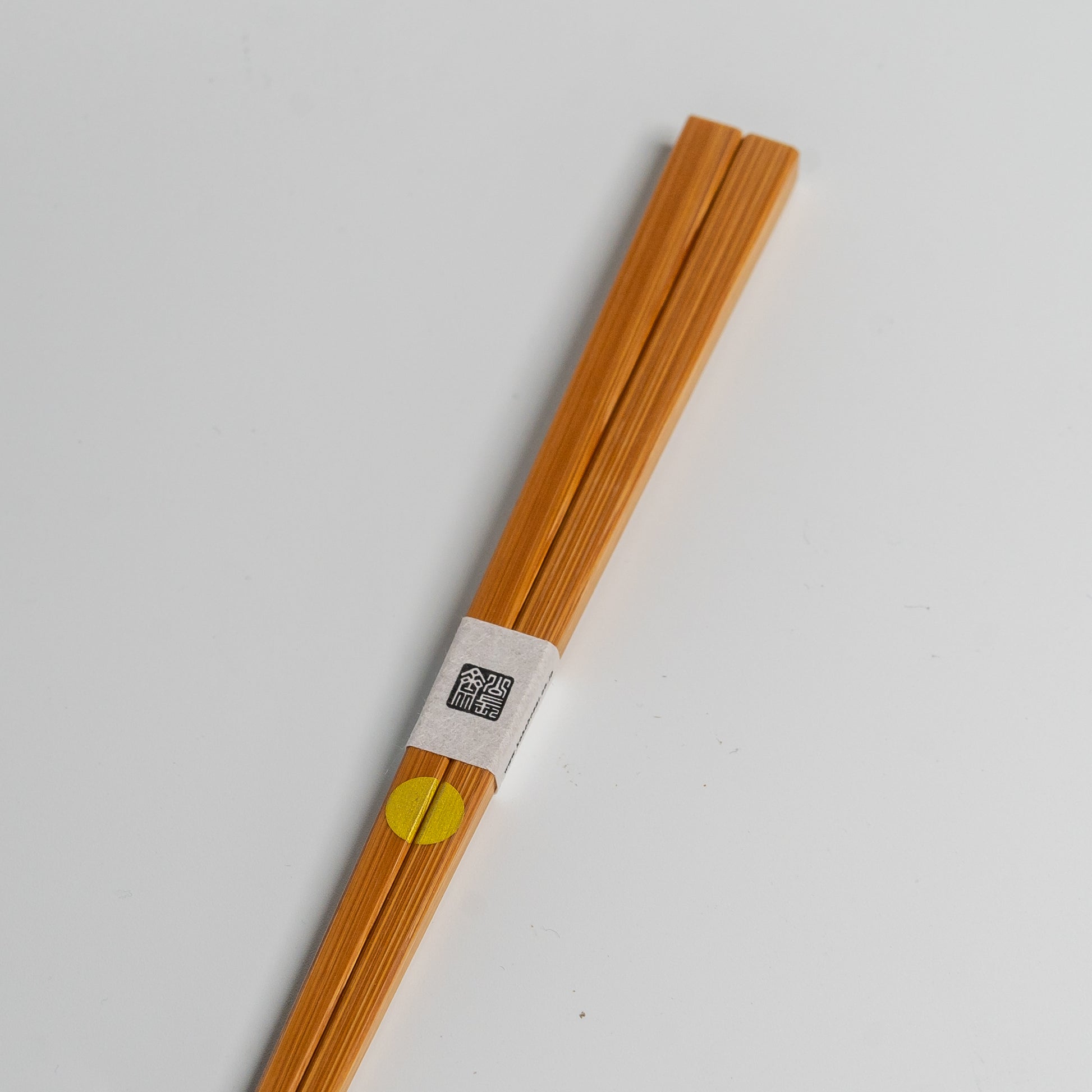 Japanese bamboo chopsticks with a gold circle on white