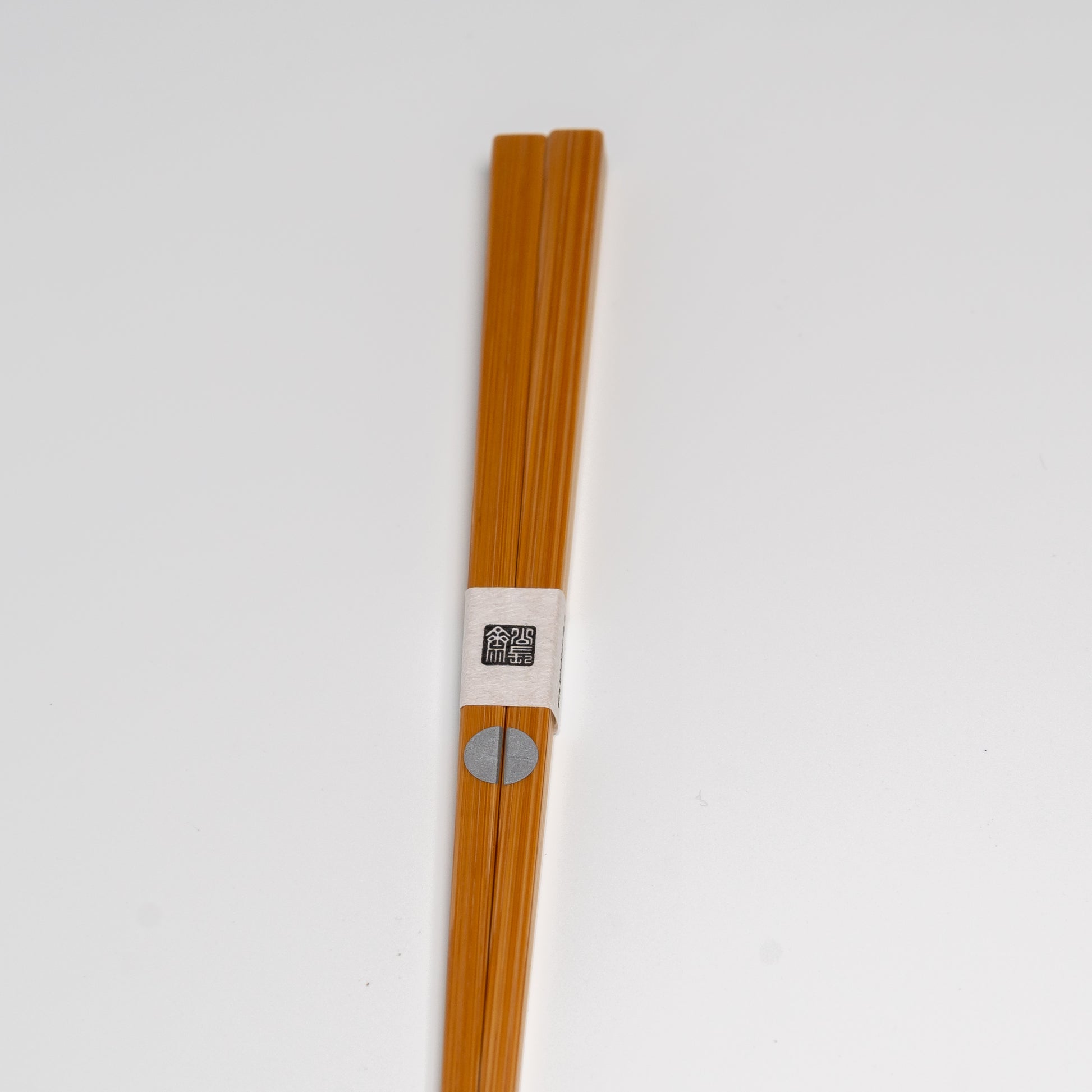 Japanese bamboo chopsticks with a silver circle on white