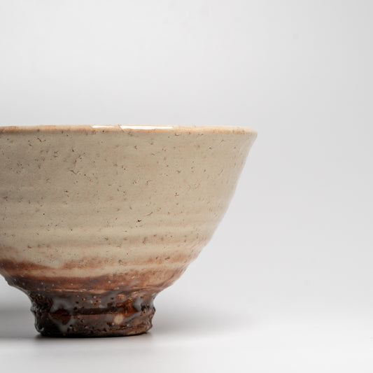 A Japanese ceramic ceremonial matcha tea bowl on a white background
