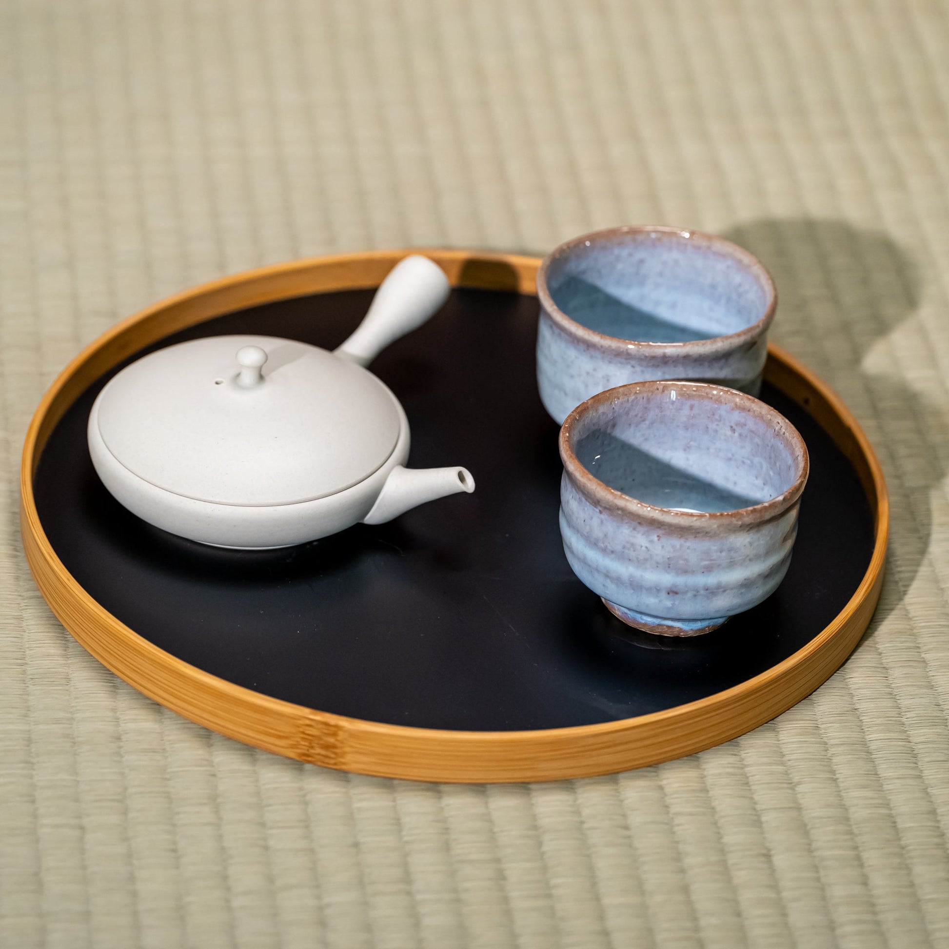 A Japanese ceramic tea set on a bamboo tray