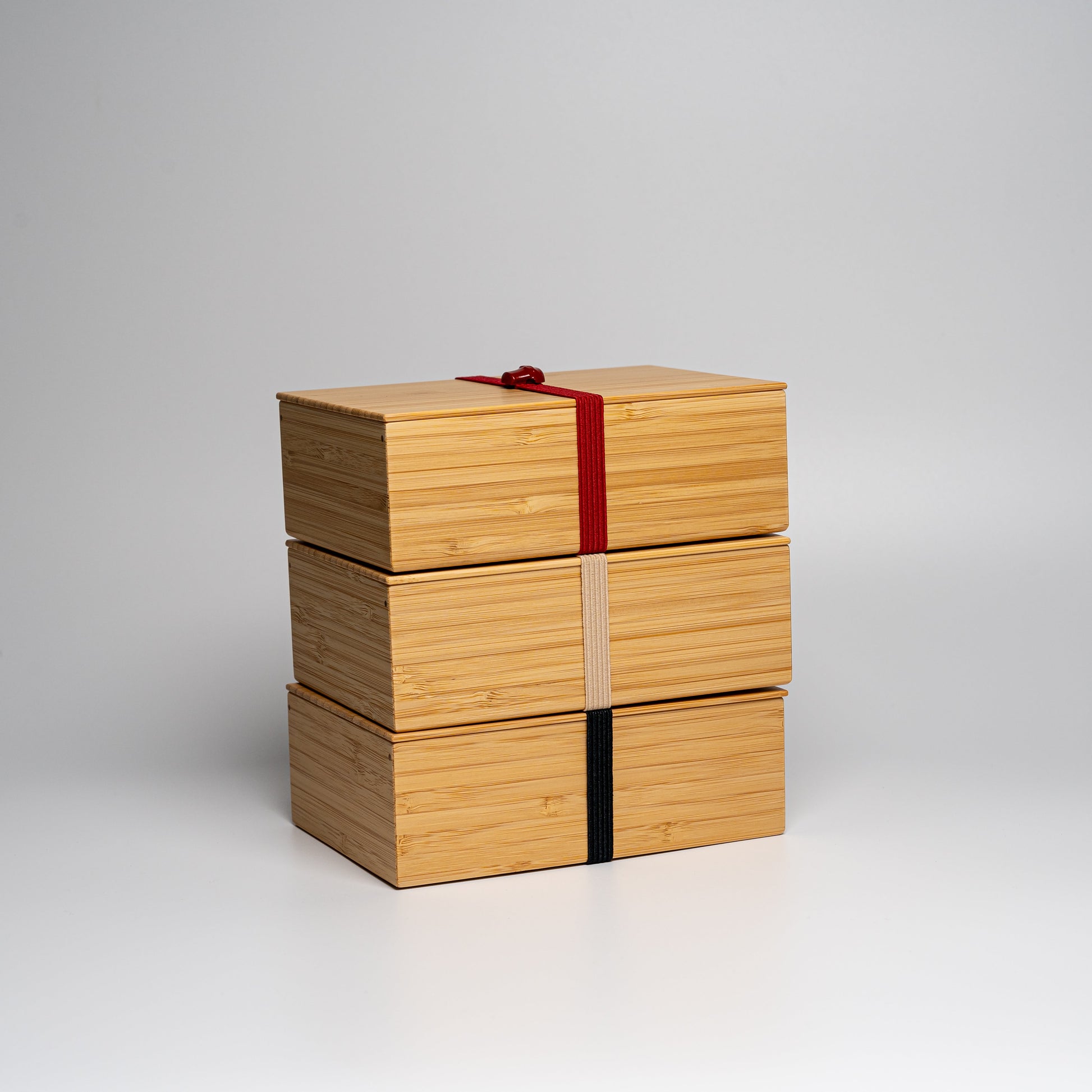 A stack of bamboo bento boxes on a white background