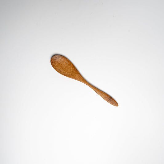 A Japanese bamboo spoon on a white background