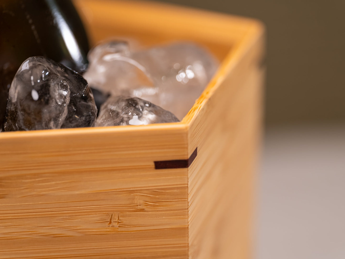 A Japanese bamboo wine cooler filled with ice and a bottle of champagne