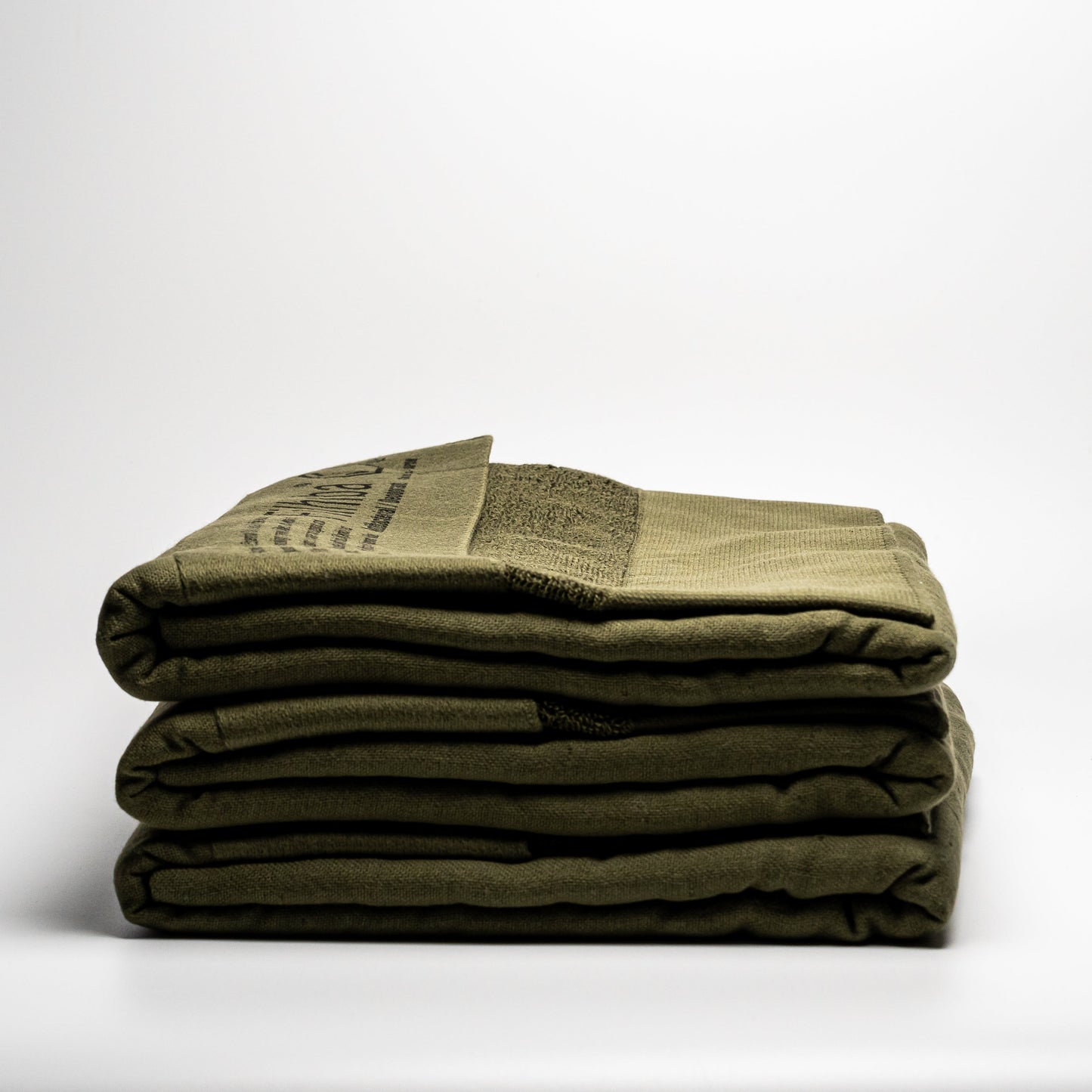 A stack of green Filhiba bath towels on a white background