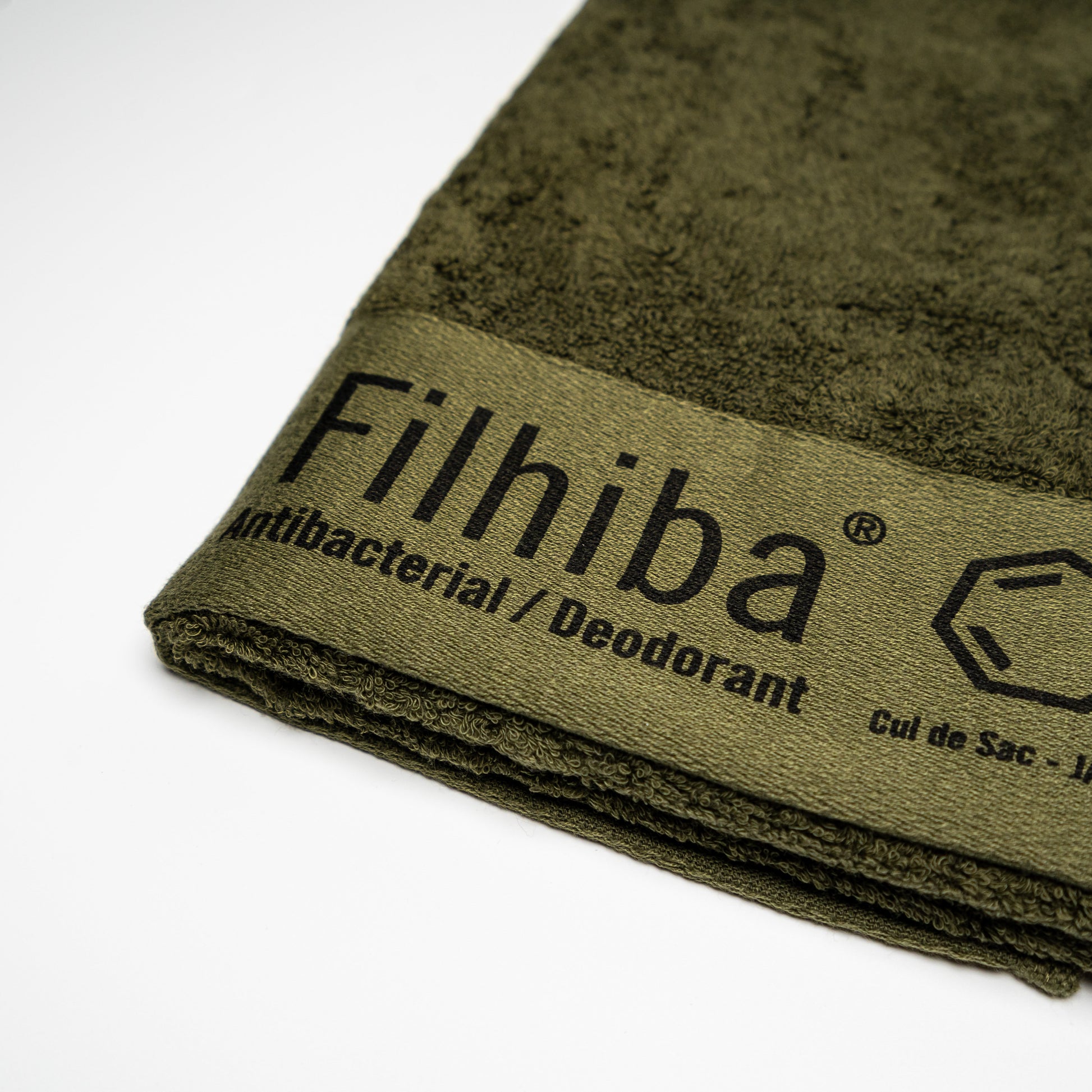 A close up of a Green Filhiba face towel on a white background