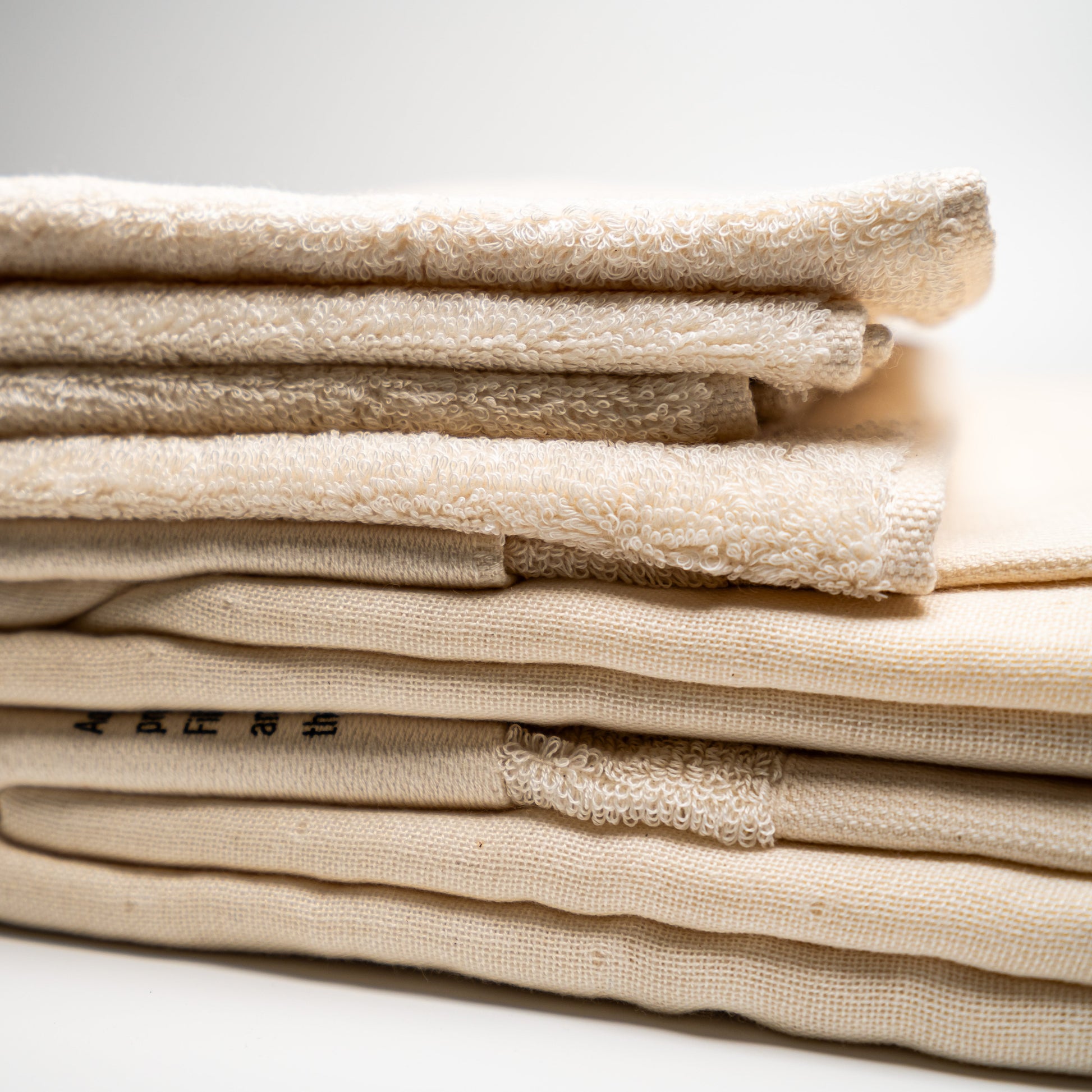 A stack of natural Filhiba towels on a white background