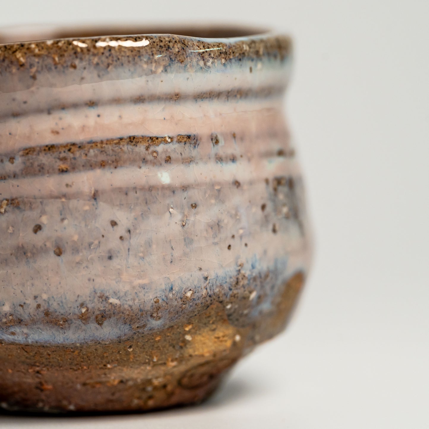 A pink Hagi yaki sake cup on a white background