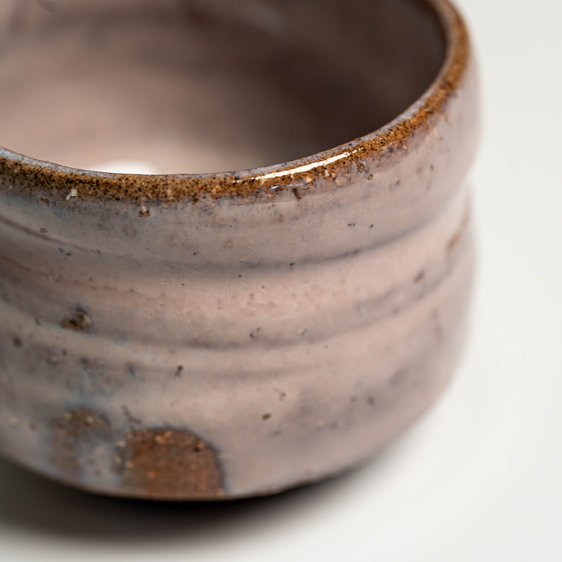 A pink Hagi yaki sake cup on a white background