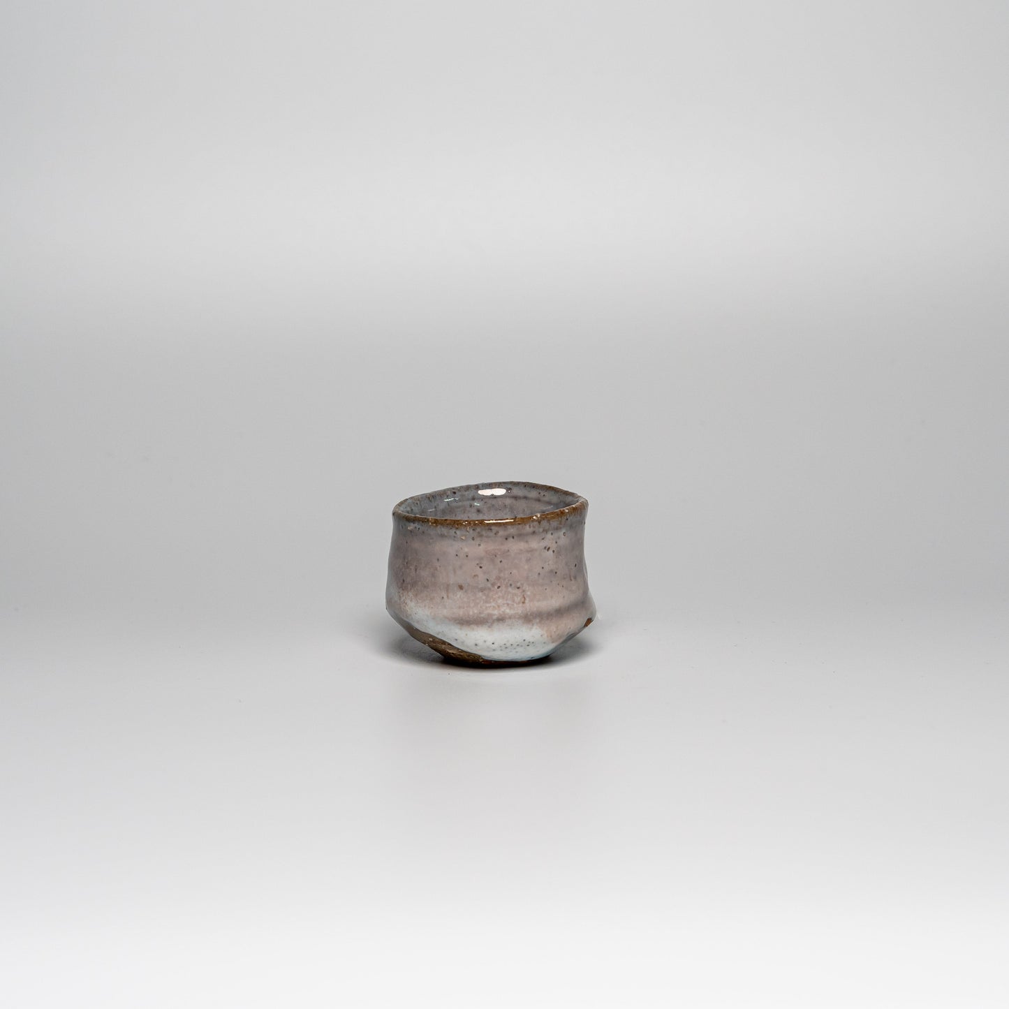 A pink and white Hagi yaki sake cup on a white background