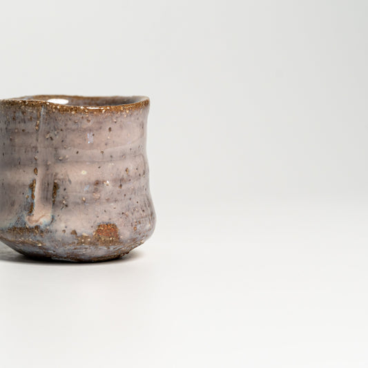 A pink Hagi yaki sake cup on a white background