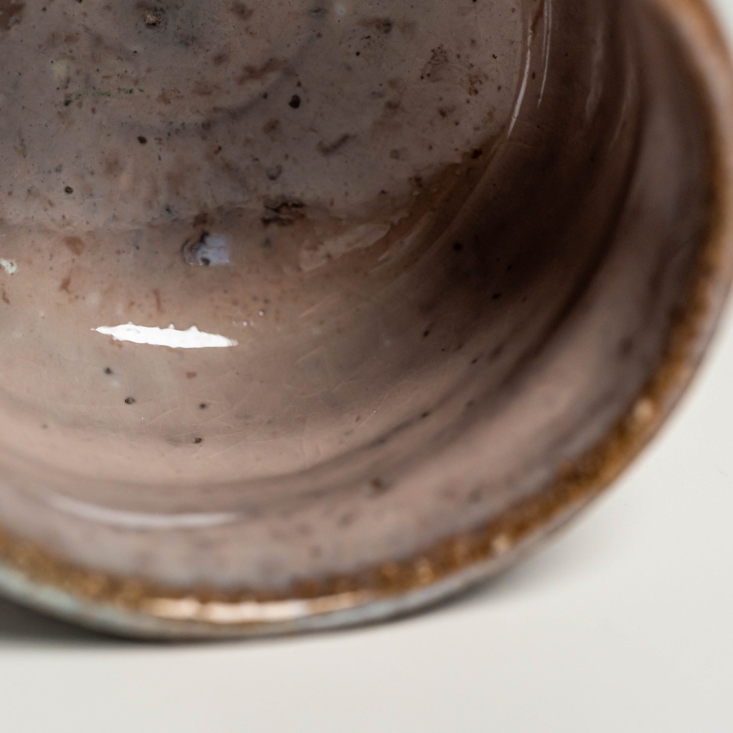 The inside of a pink Hagi yaki sake cup on a white background