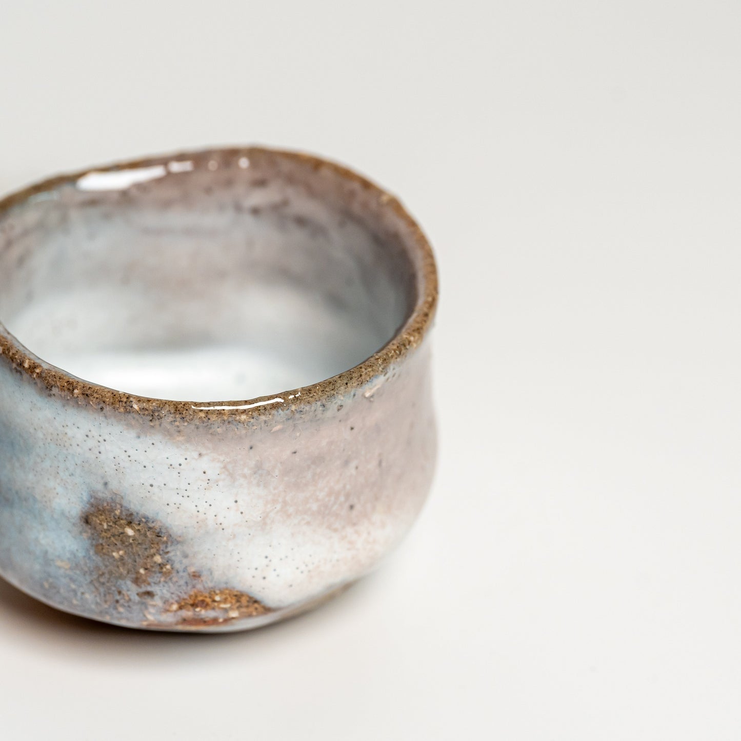 A pink and white Hagi yaki sake cup on a white background